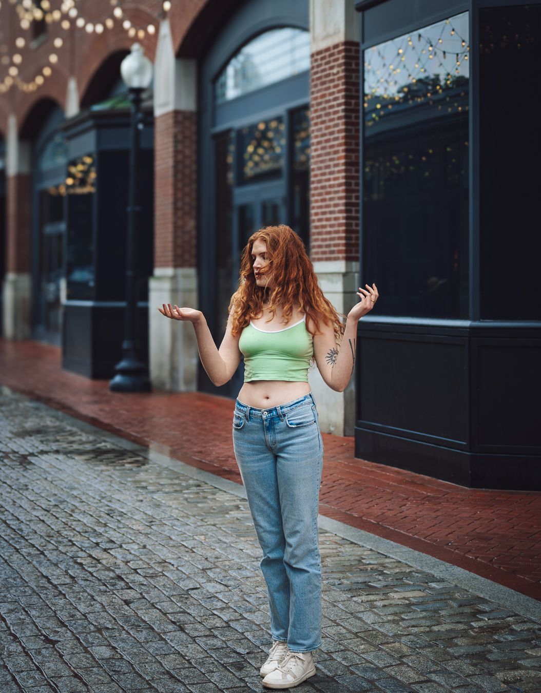 Street portrait of a red-haired woman walking along a brick sidewalk