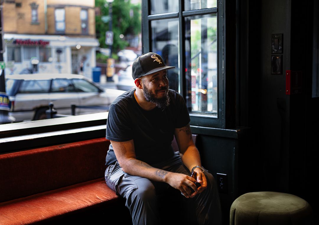 Environmental portrait of a man seated beside a large window