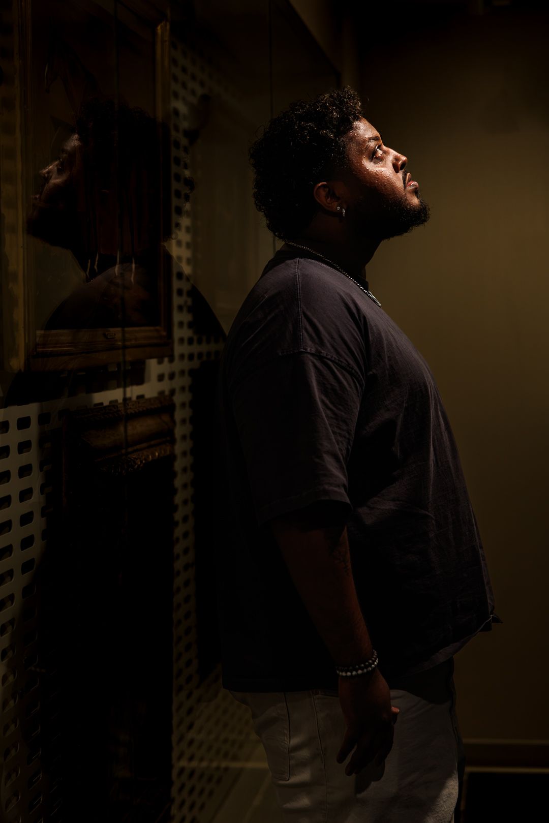 Dramatic portrait of a man looking upward into a beam of light