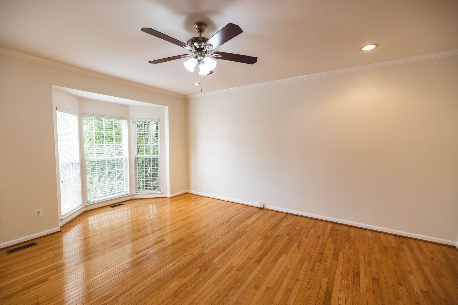 Empty living room with hardwood floors and large glass doors
