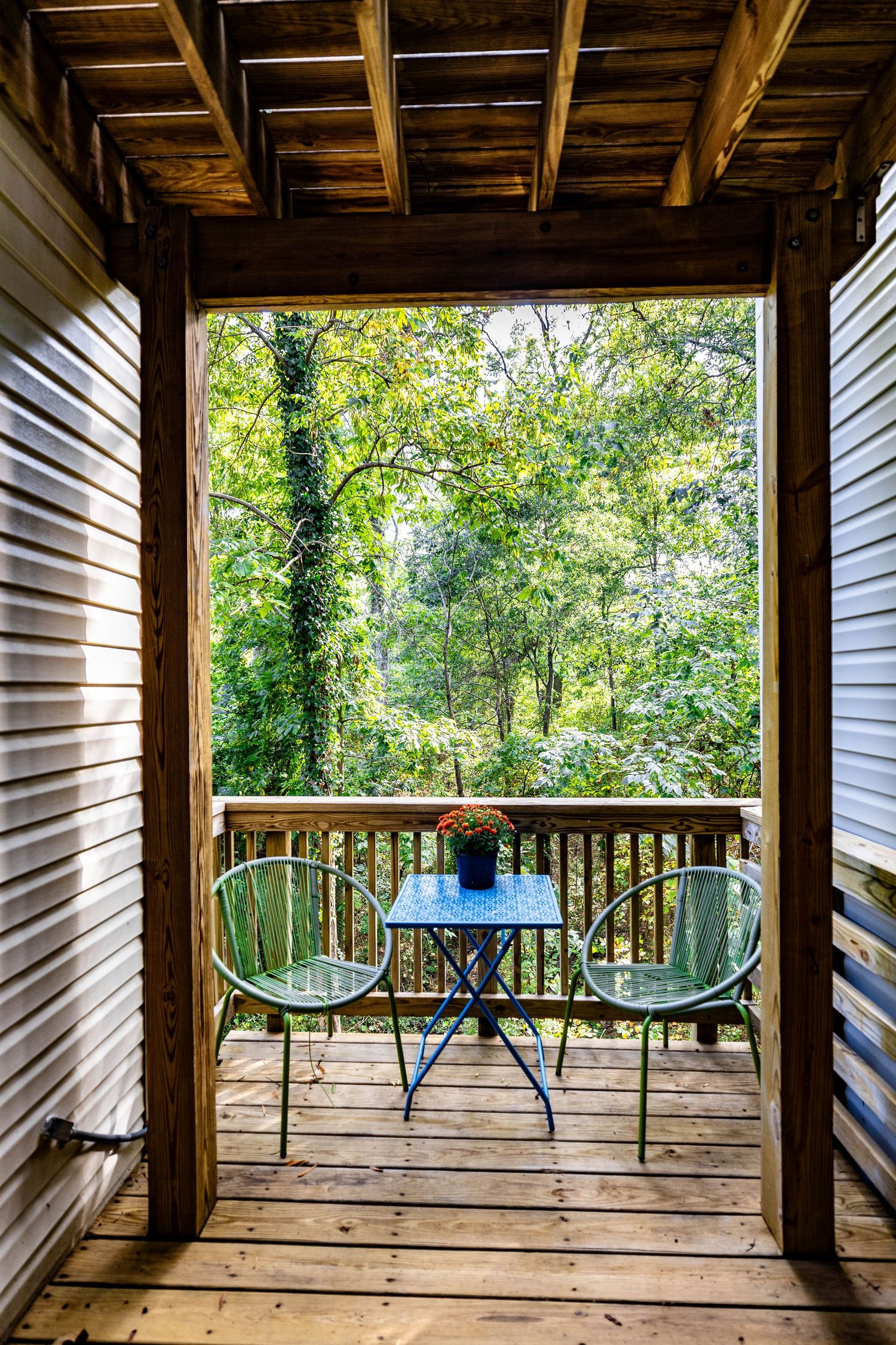 Covered residential patio overlooking green trees