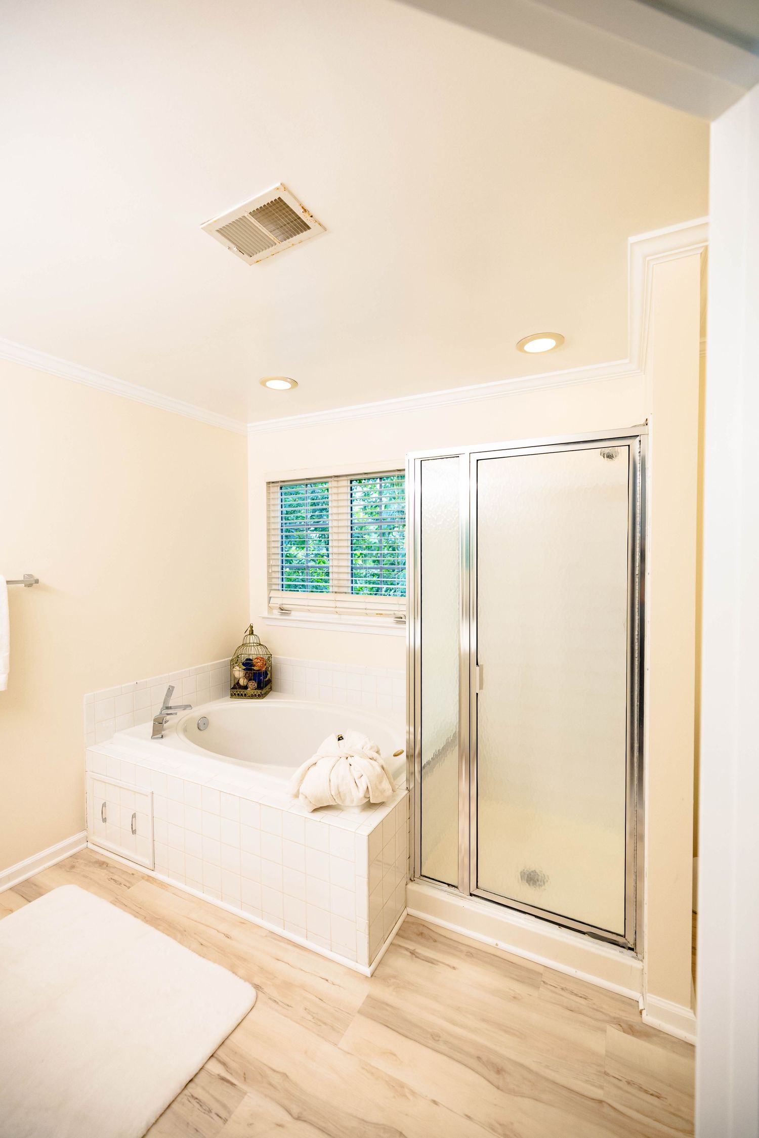 Bright primary bathroom with glass shower and white finishes