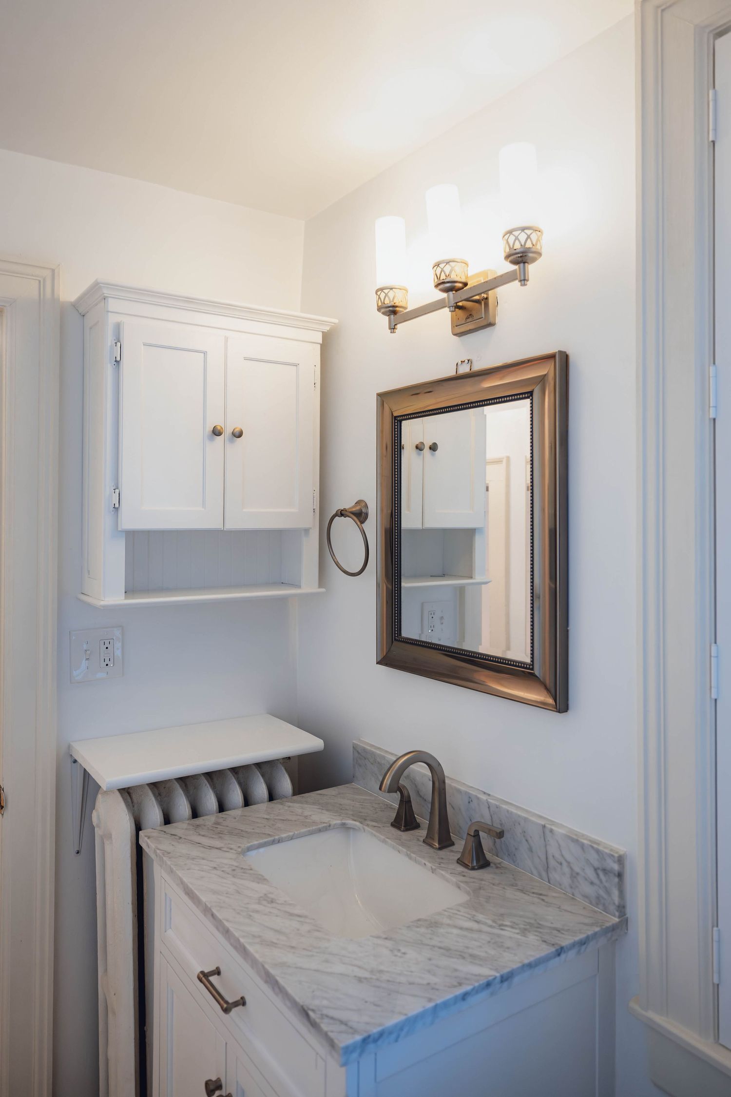 Small bright bathroom with white vanity and wall mirror