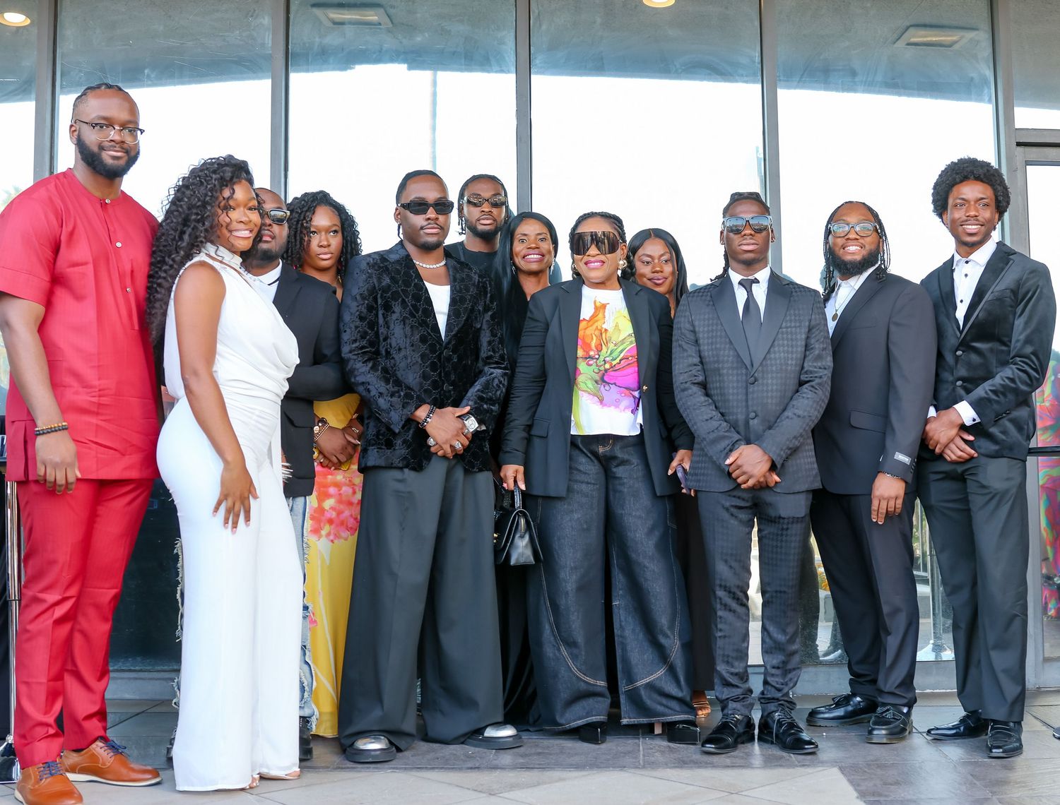 Large group photo of people in formal business attire standing together indoors.