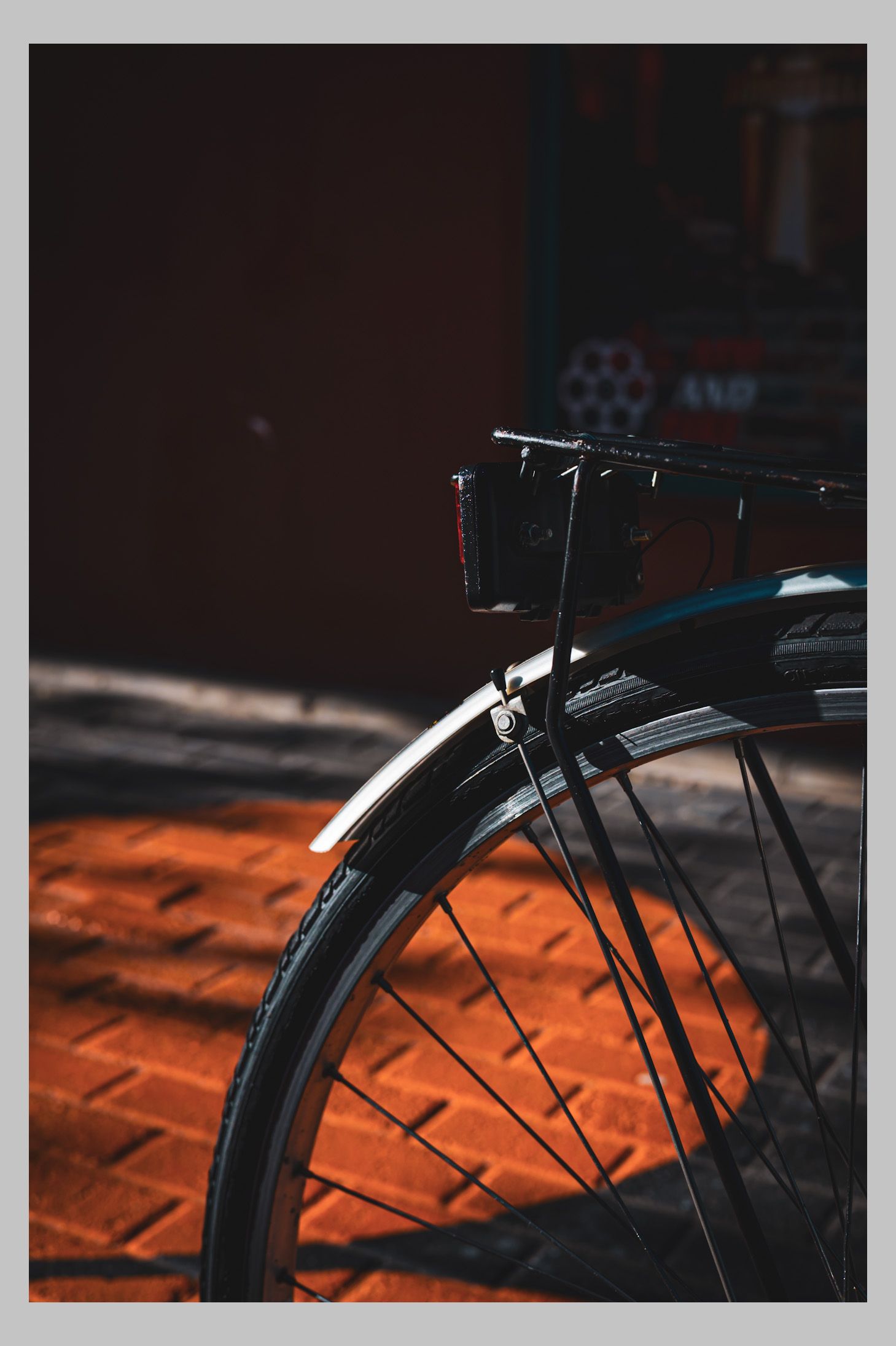 Bicycle parked beside warm brick pavement lighting