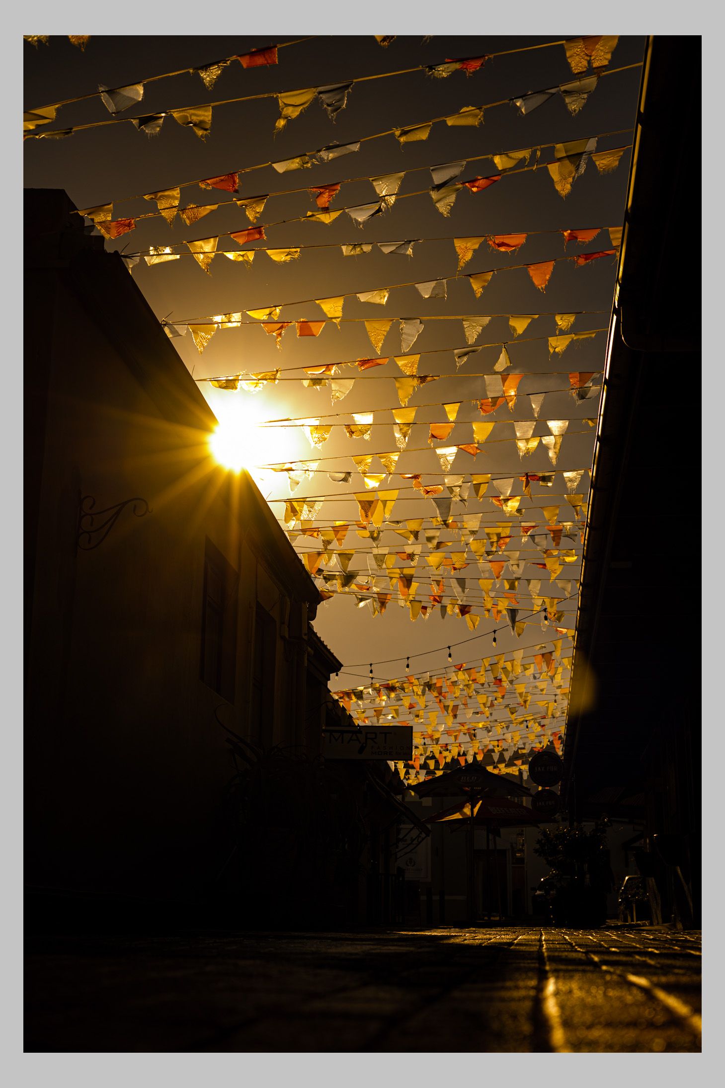 Golden sunlight shining through hanging street decorations