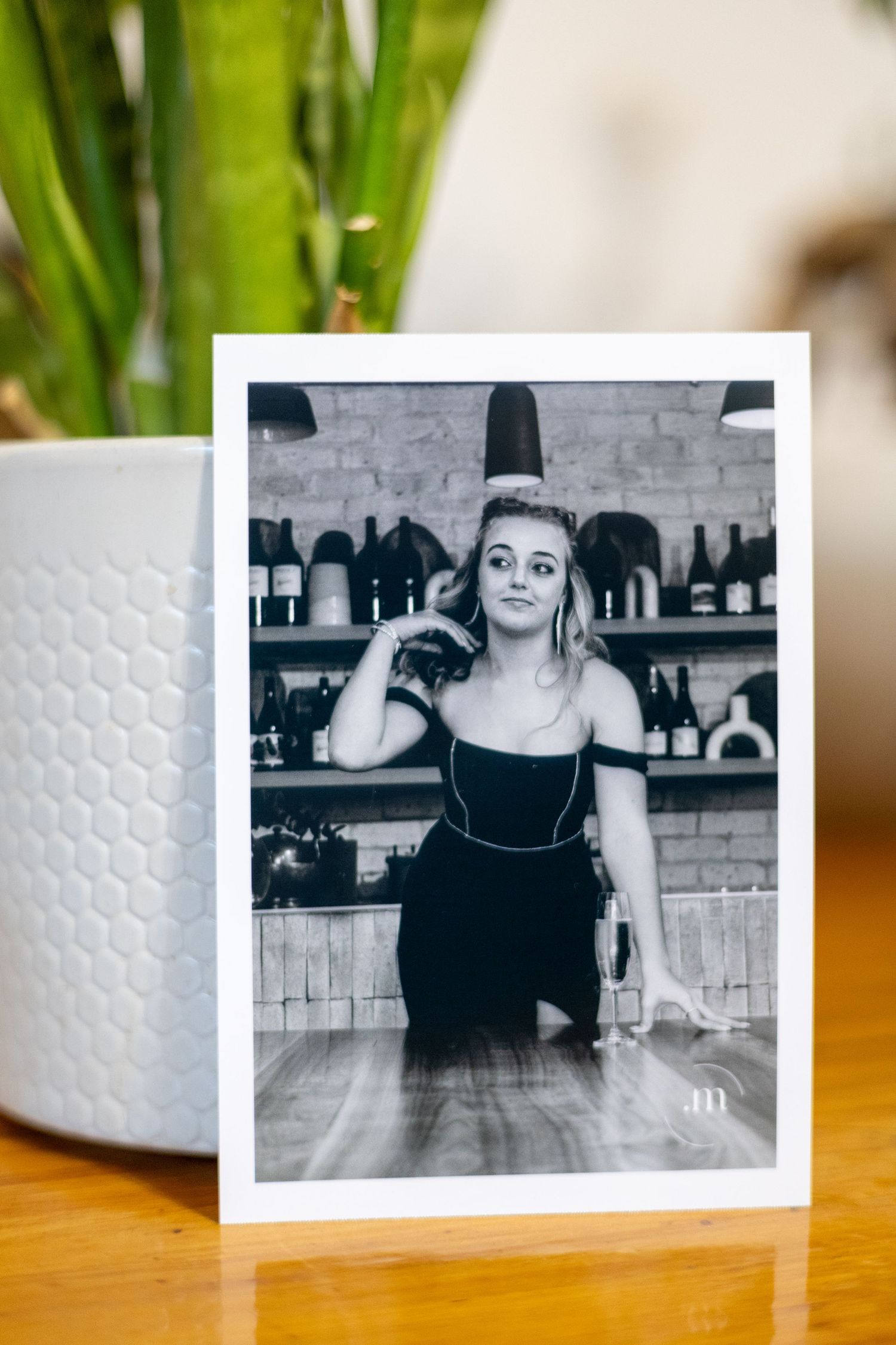 Printed black and white portrait beside indoor plant decor