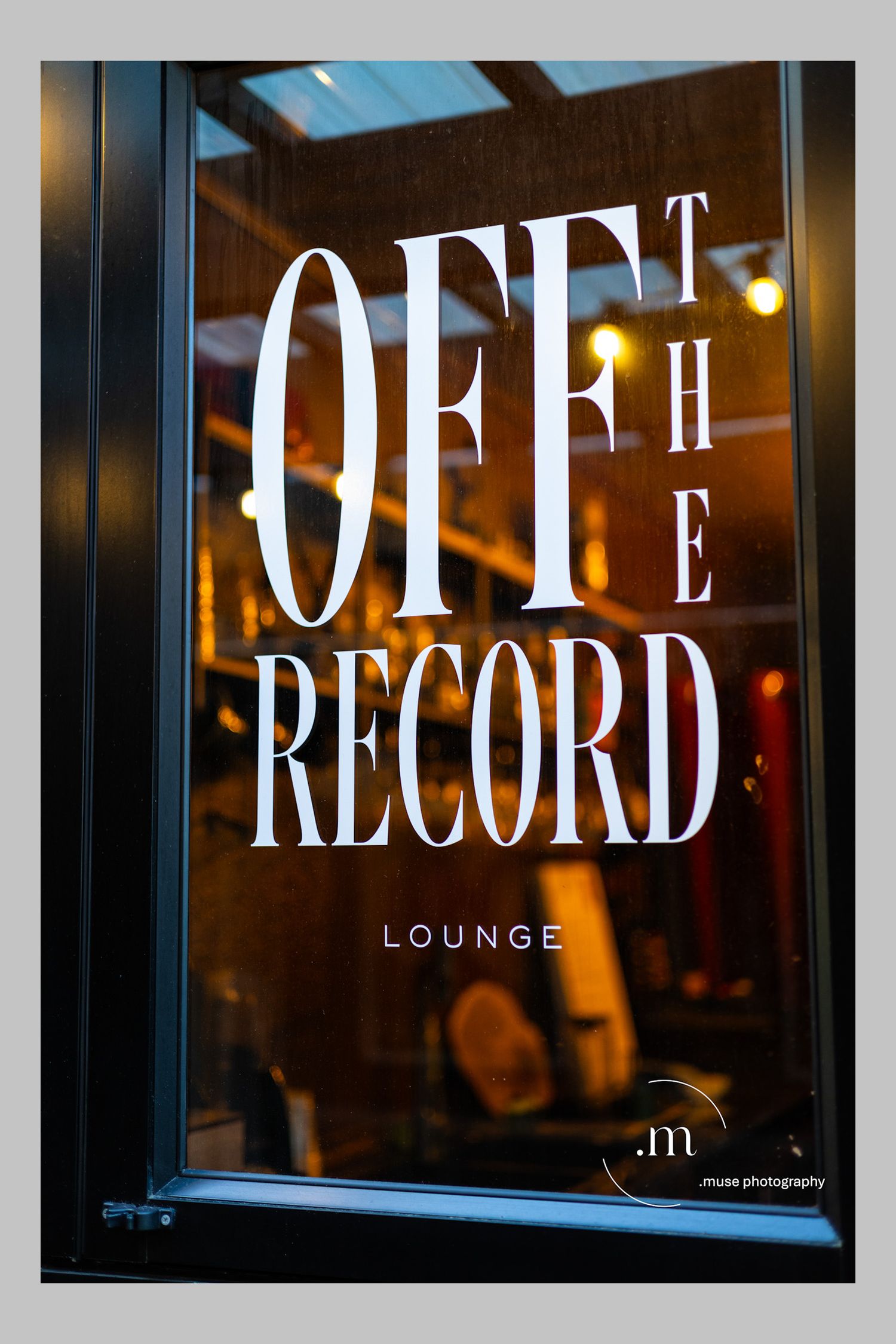Vintage lounge sign glowing through a window at night