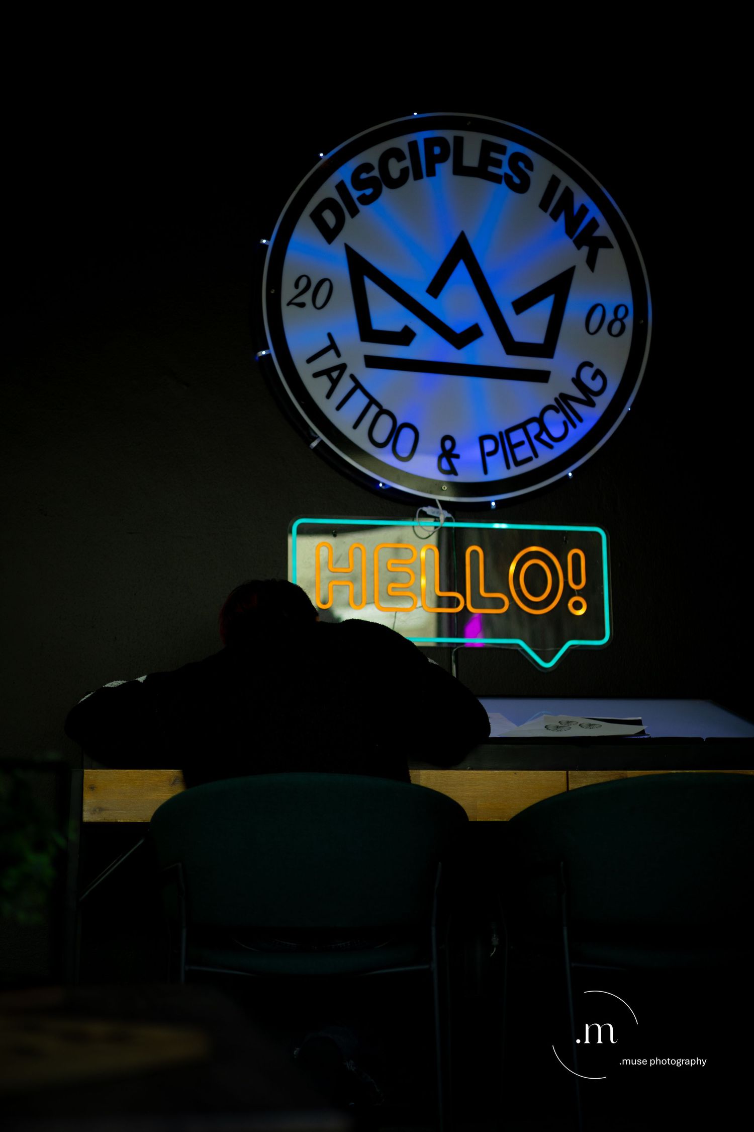 Tattoo studio neon sign glowing in a dark interior