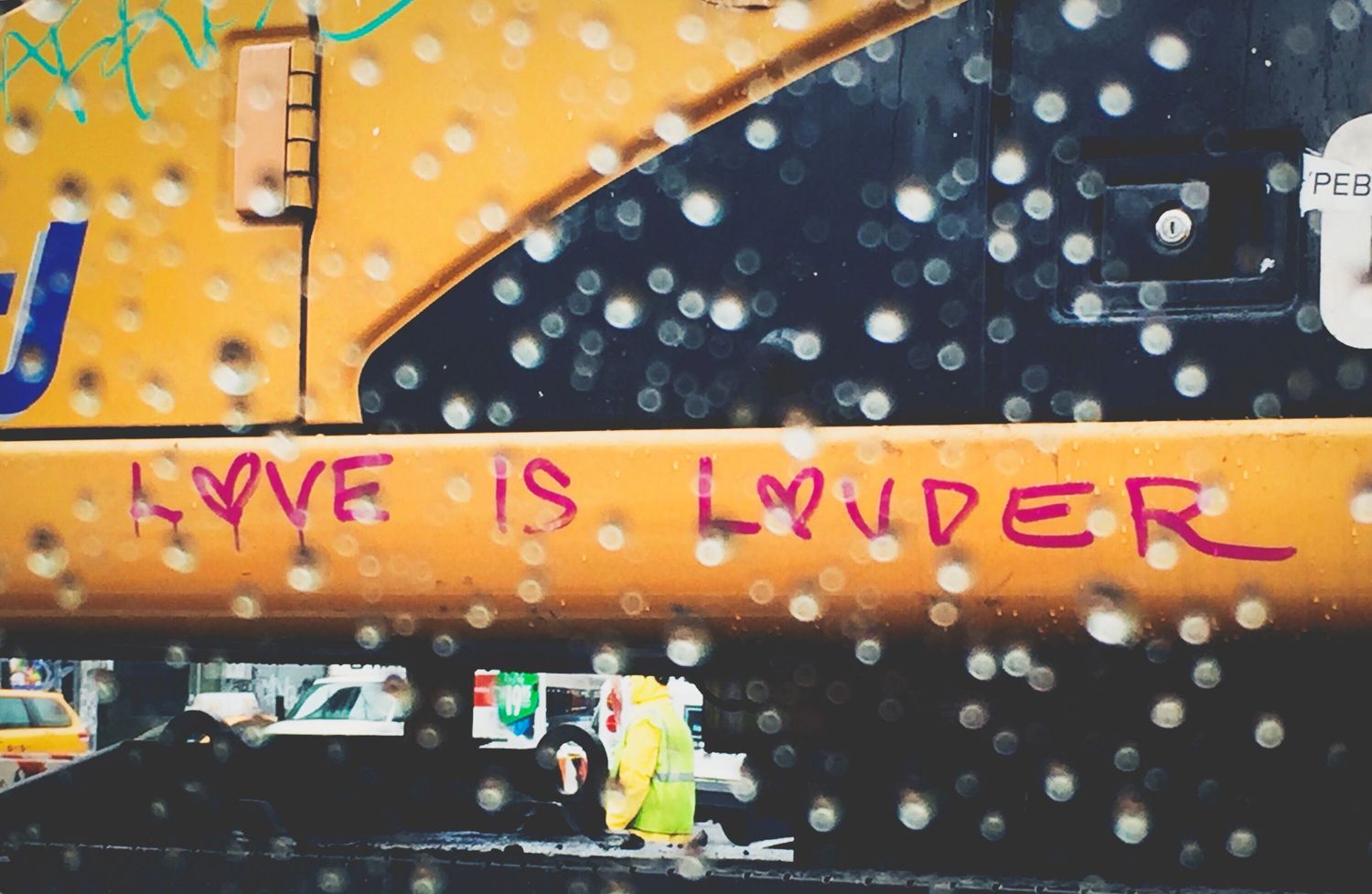 Colorful graffiti wall with raindrops and text patterns in orange and dark tones.
