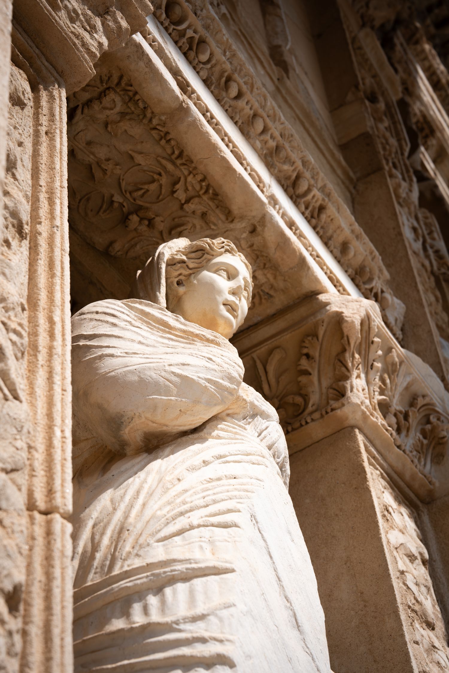 Ancient stone carved figures and architectural details on classical building facade.