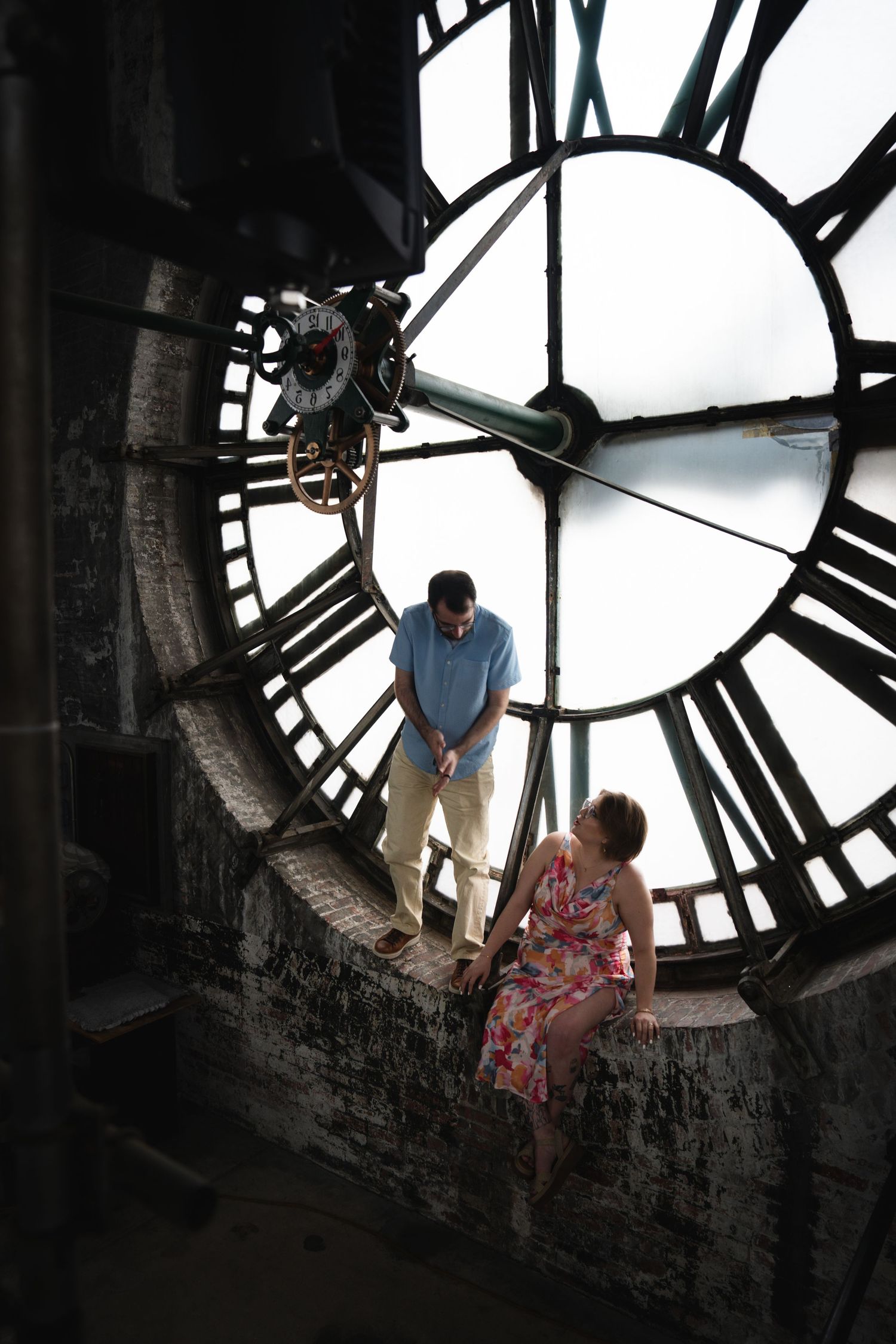 Romantic photoshoot inside a clock tower with dramatic lighting and architecture.