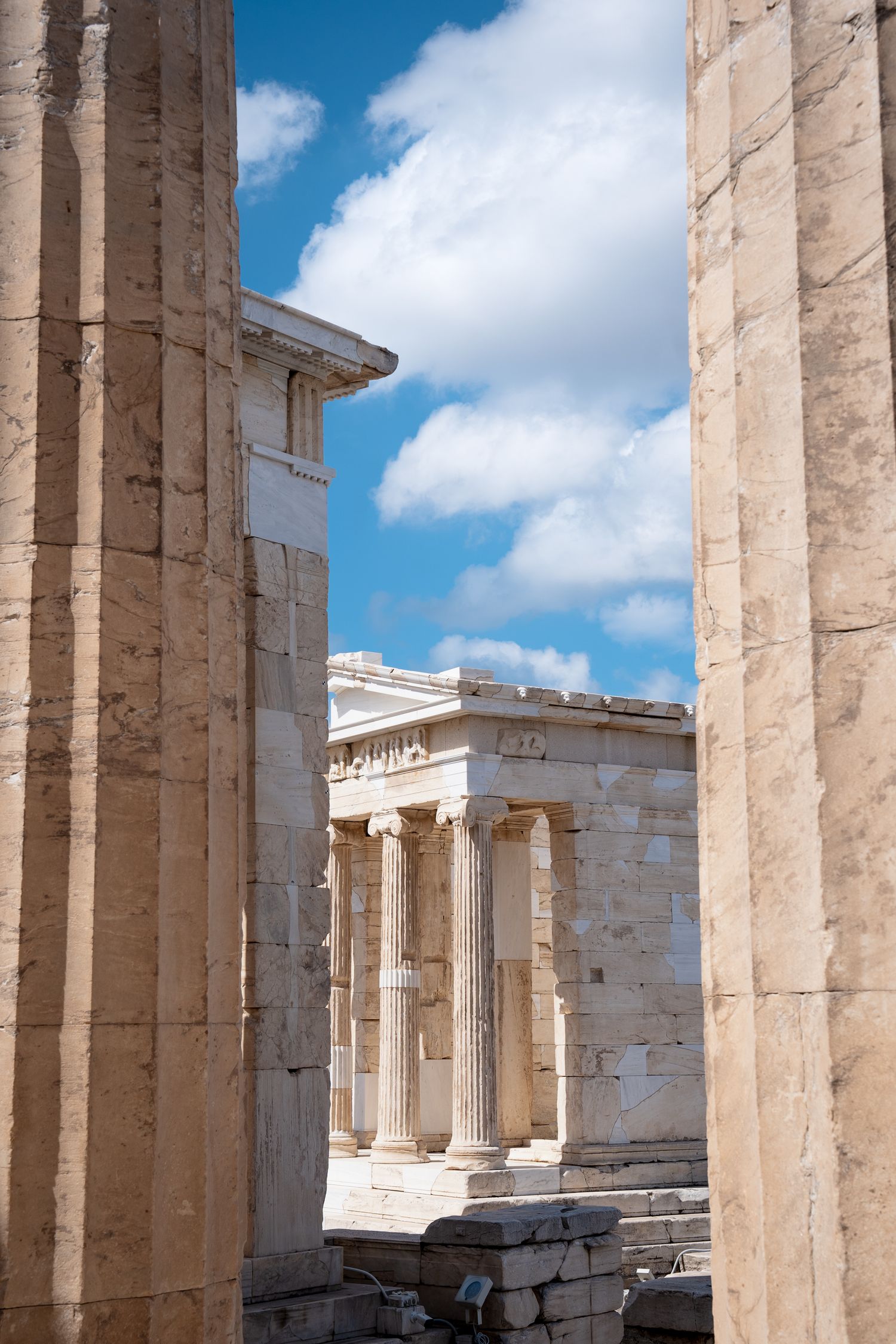 Classical Greek temple columns and architecture with blue sky background.