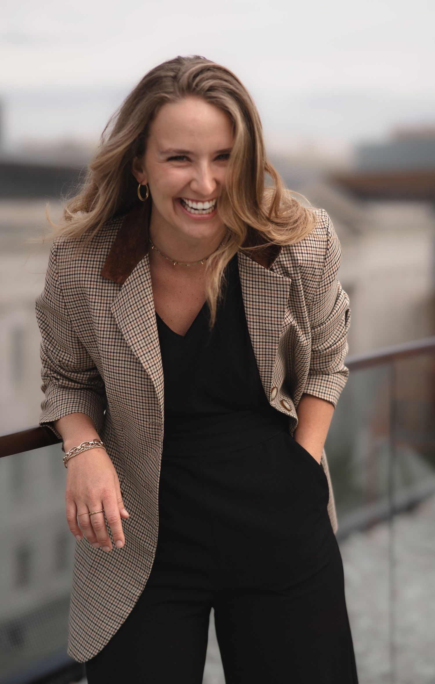 Candid professional shots of someone in a plaid blazer and black top near a glass railing.