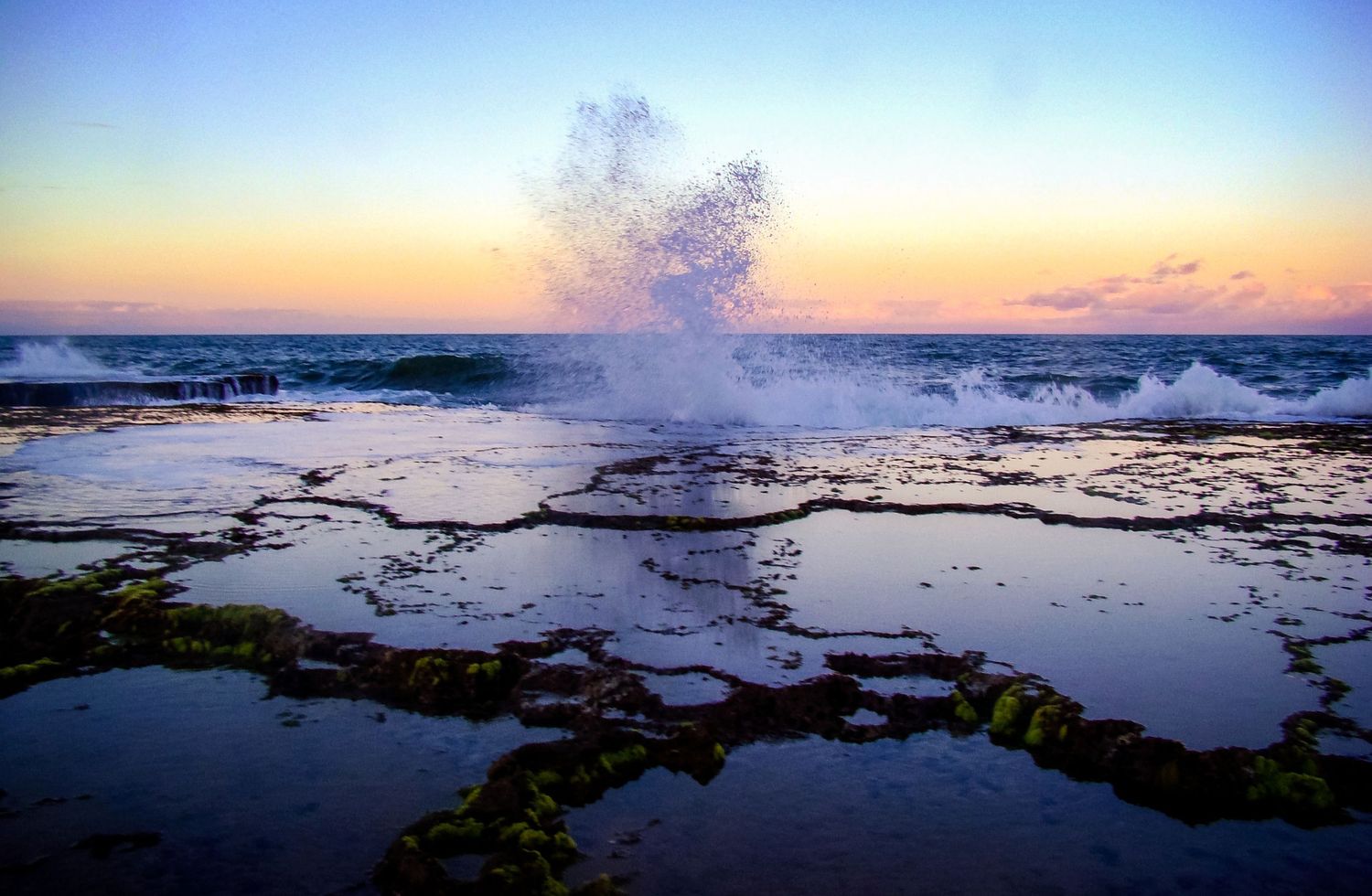 Panoramic series of coastal tide pools reflecting a vibrant sunset sky over the ocean horizon.
