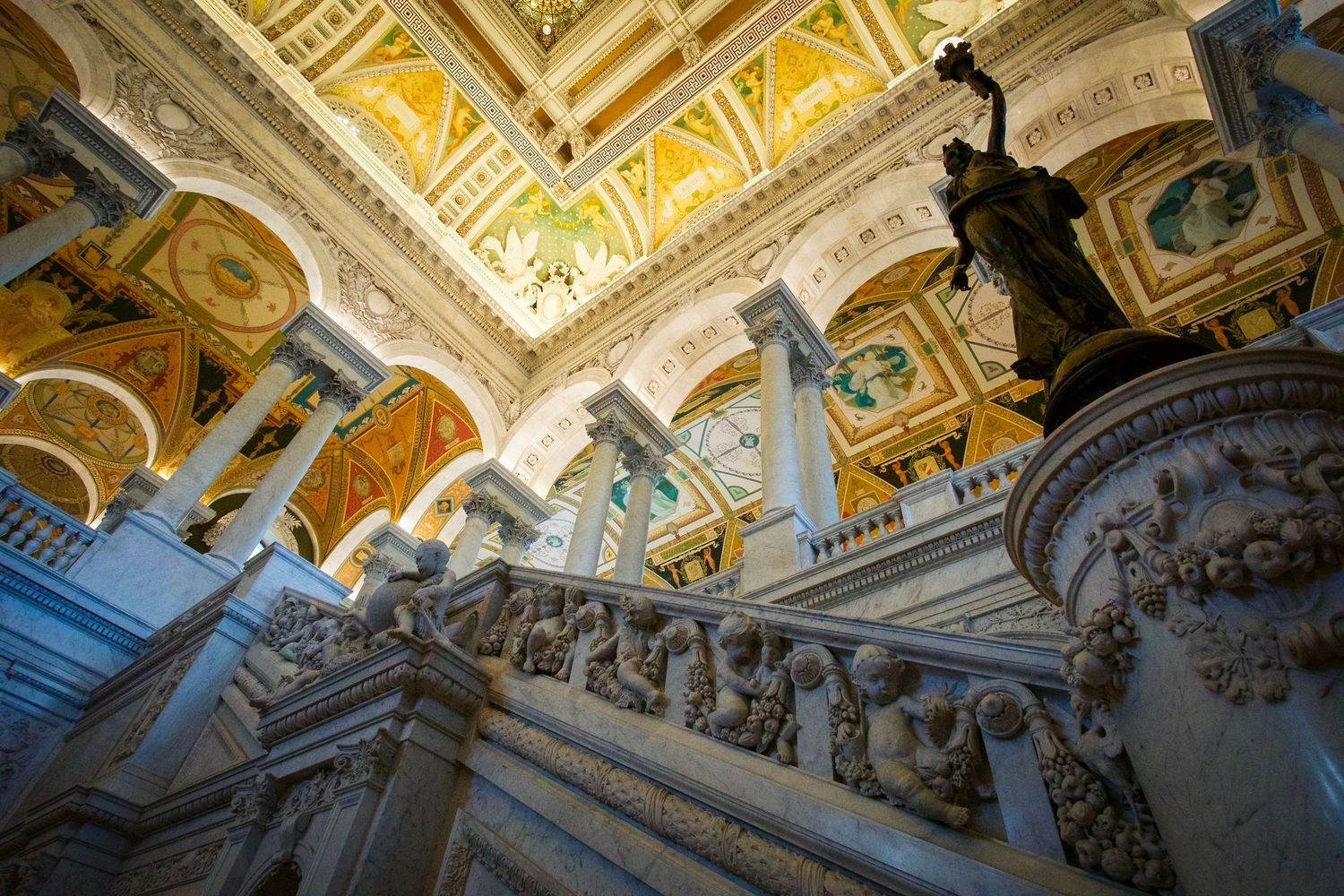 Ornate baroque architecture with gold ceiling details and grand staircase in historic building.