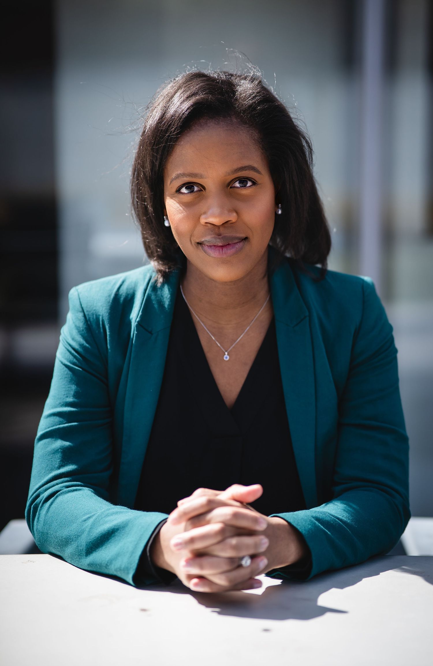 Corporate portrait series showing professional poses in teal blazer and black top.
