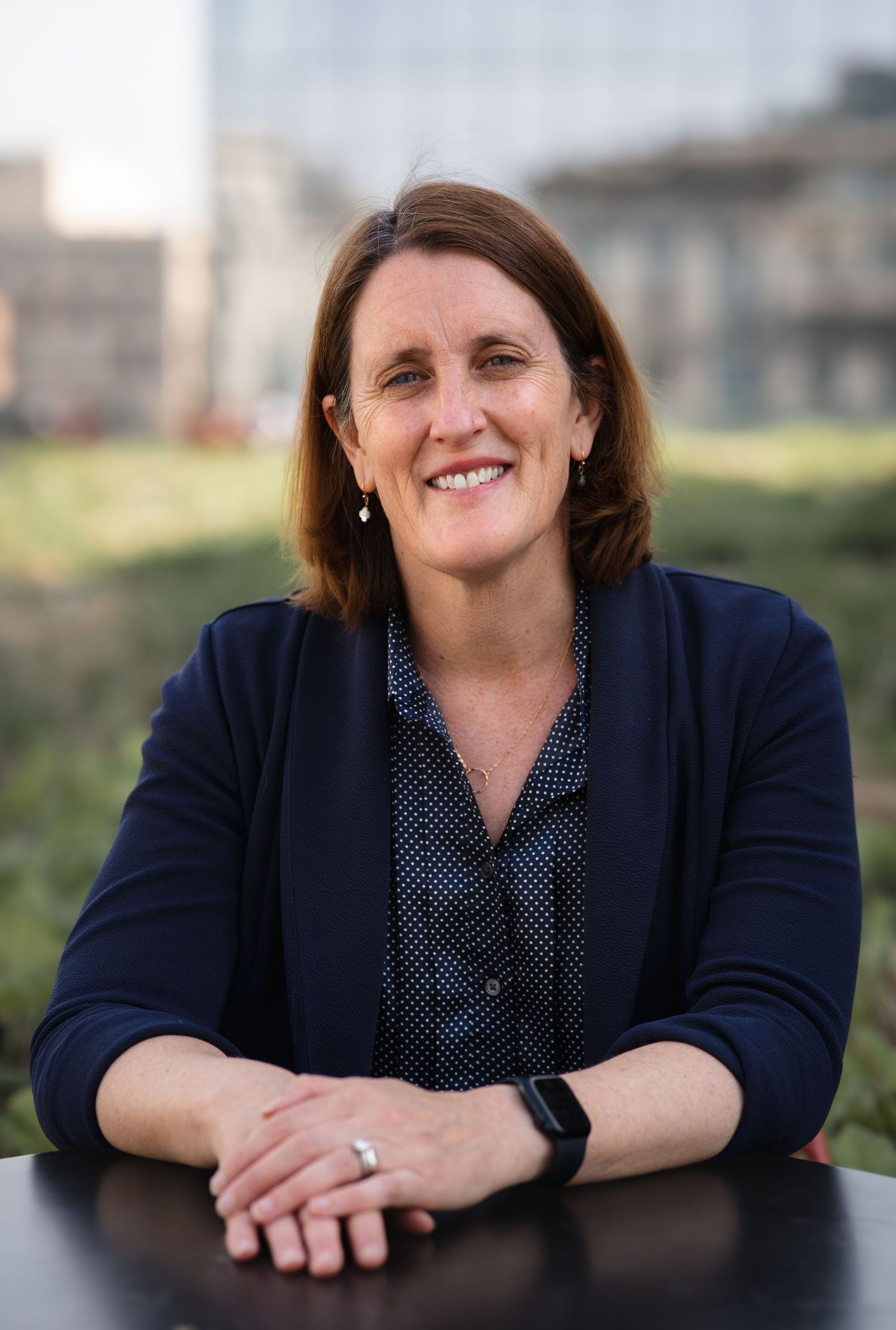 Business portraits featuring someone in professional attire leaning on a surface with natural lighting.
