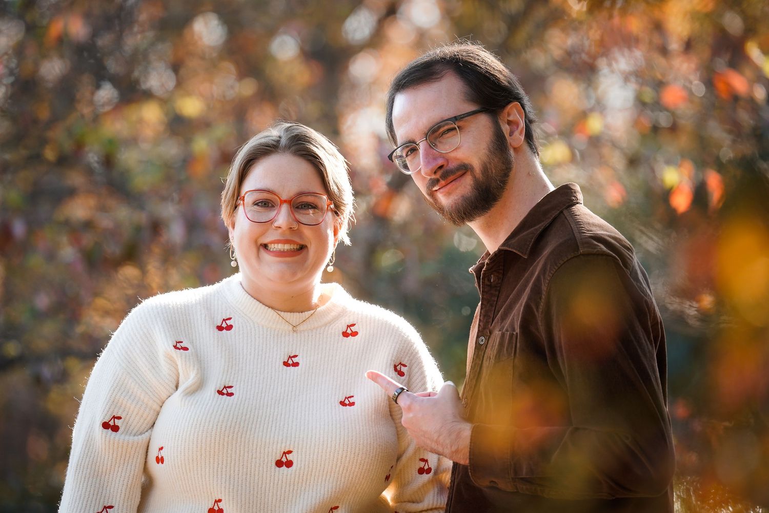 A playful autumn photoshoot with a couple surrounded by fall foliage.