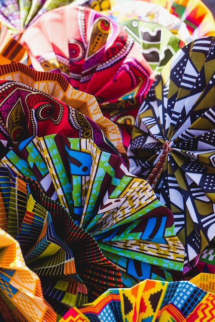 Vibrant African wax print fabrics display colorful geometric patterns and designs.