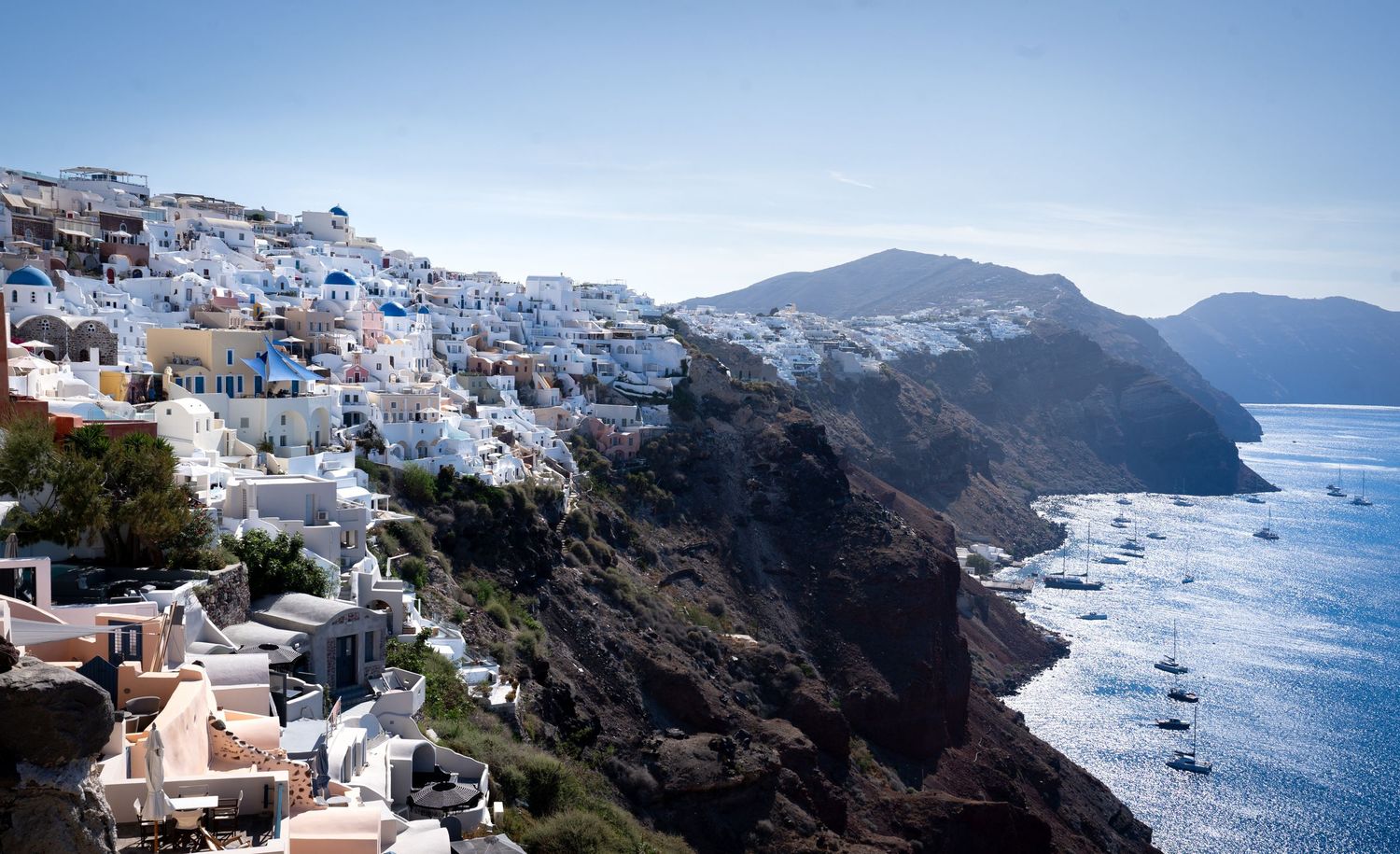 White buildings cascading down cliffs overlooking the Mediterranean Sea in Santorini.