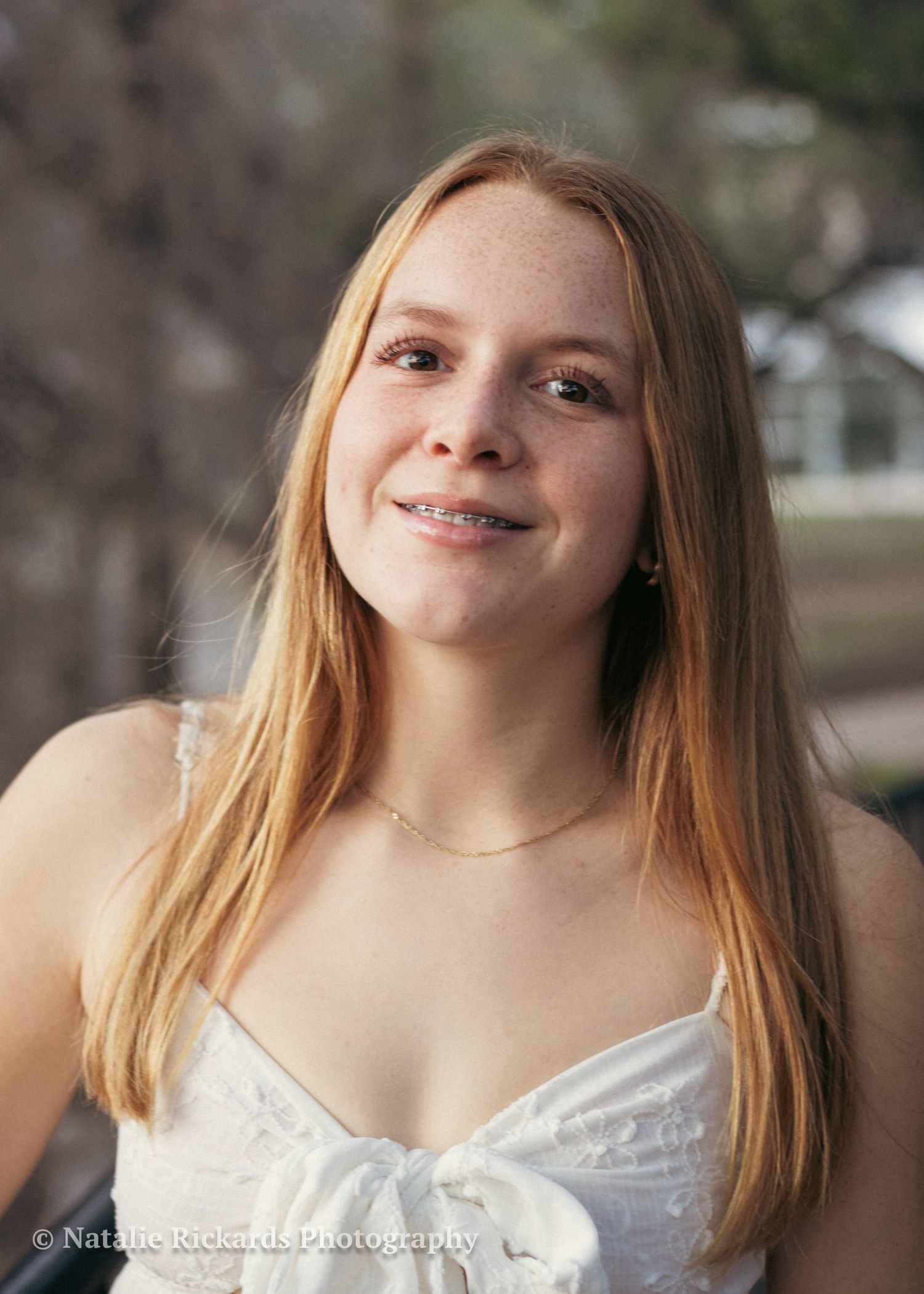 Senior portrait in Austin in The Arboretum, dress look, serene smile.