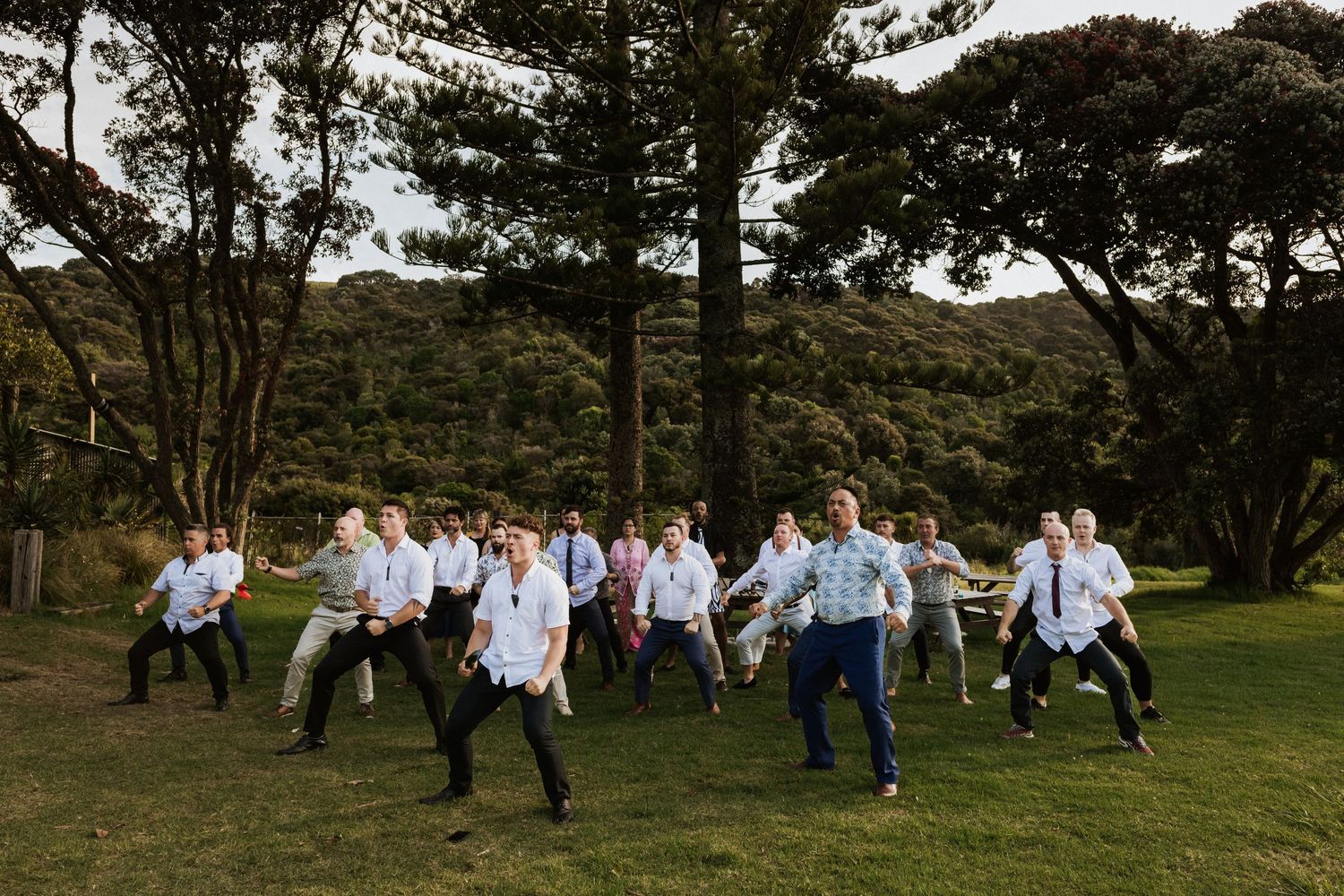 A large group of men do the Haka for a returning bride and groom