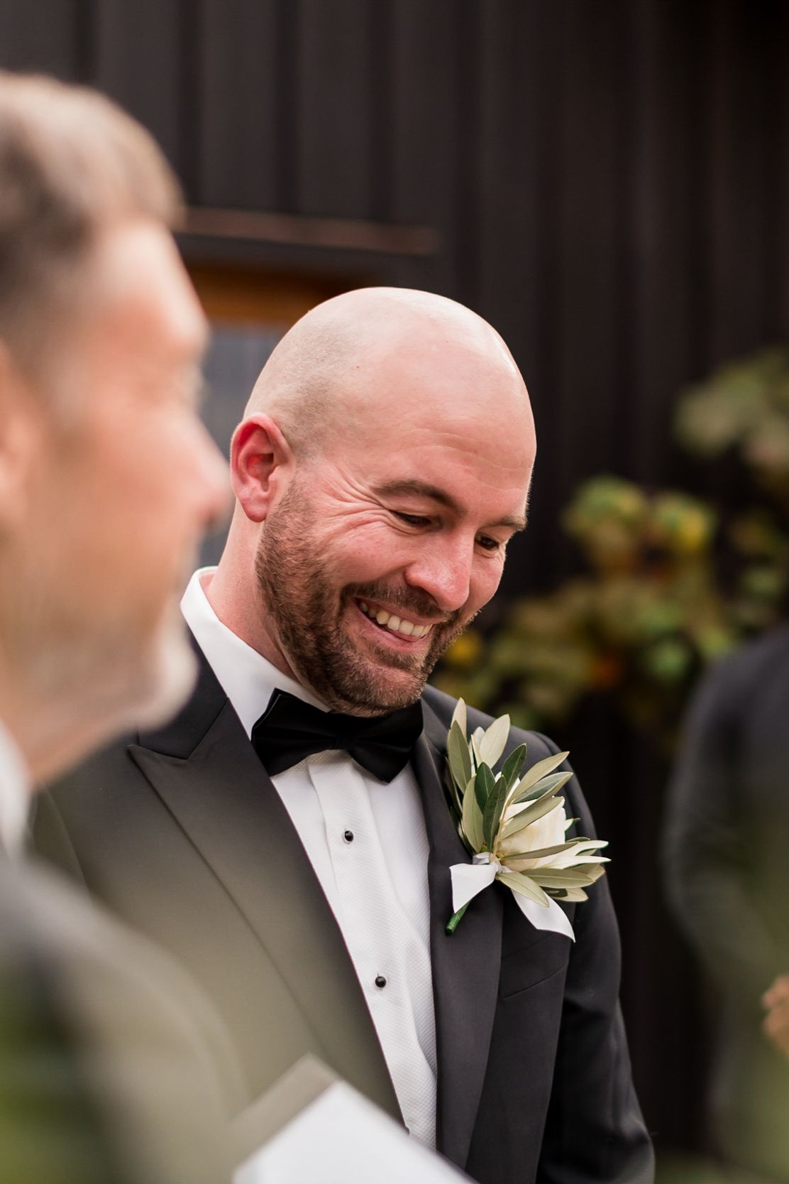 a grooms face at the end of the isle looking emotional and speechless as he sees his bride for the first time at his Waiheke Mudbrick