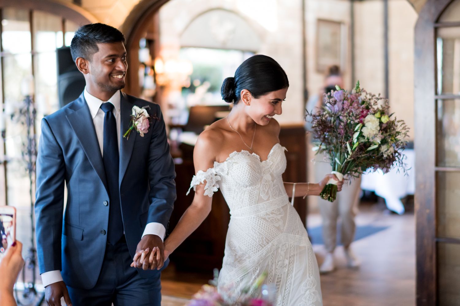 a bride and groom are excited whilst they enter the reception