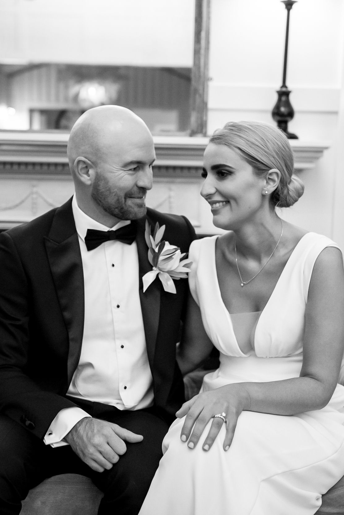 a bride and groom sit looking at each other