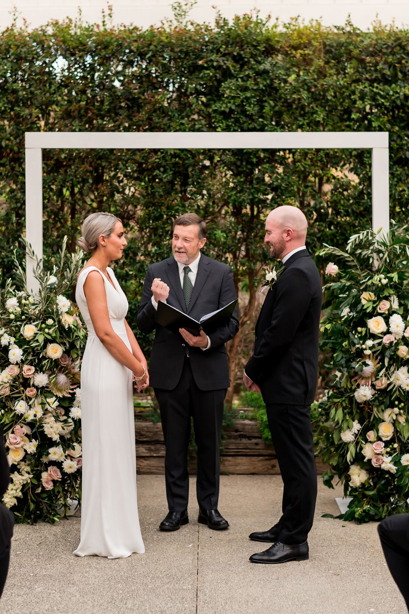 a bride and groom stand across from each other during the ceremony