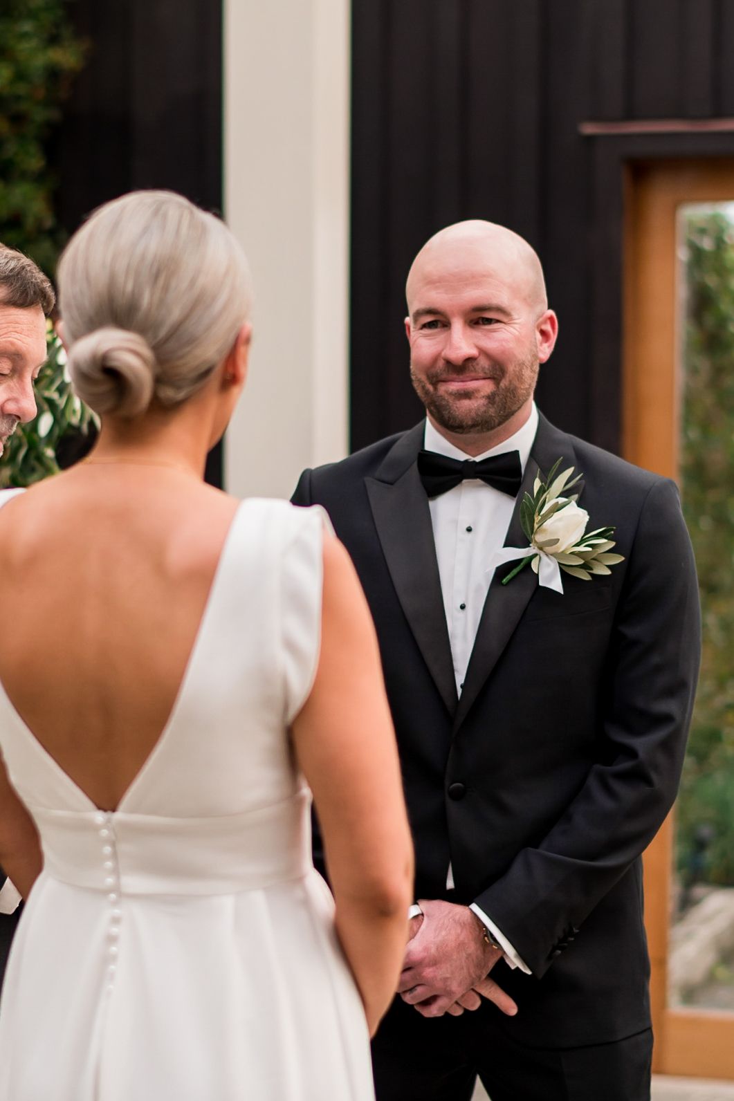 a Mudbrick wedding a groom looks across to his bride whilst they are getting married
