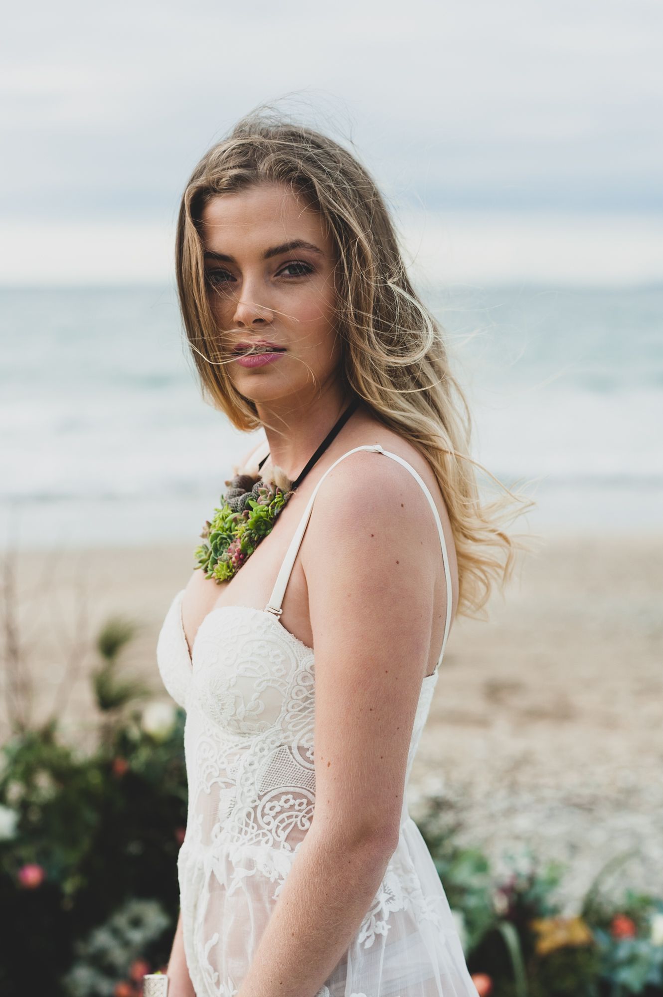 a bride looks over her shoulder towards the camera with a soft look on her face, her natural beauty shines through