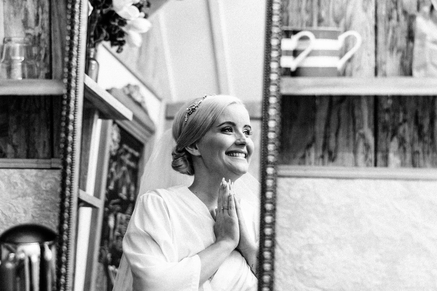 a reflection of a bride in a mirror looking excited about her coming wedding, she is getting ready and it is a glimpse of her emotions