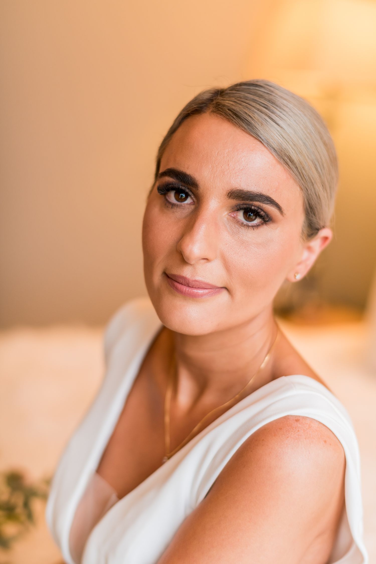 a bride looks straight towards the camera with a natural smile on her face