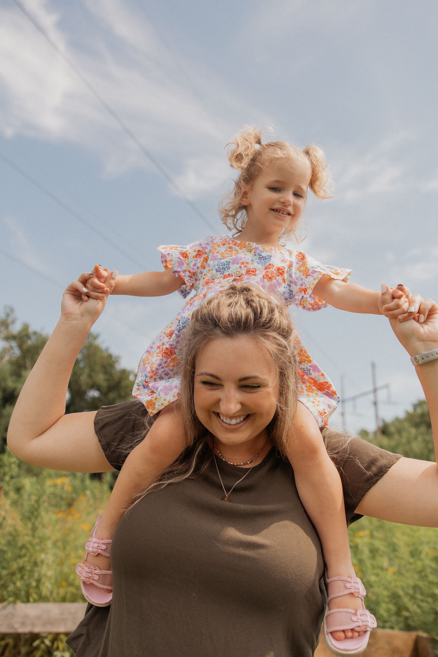 Carefree moments shared on shoulders during an outdoor photoshoot in nature.