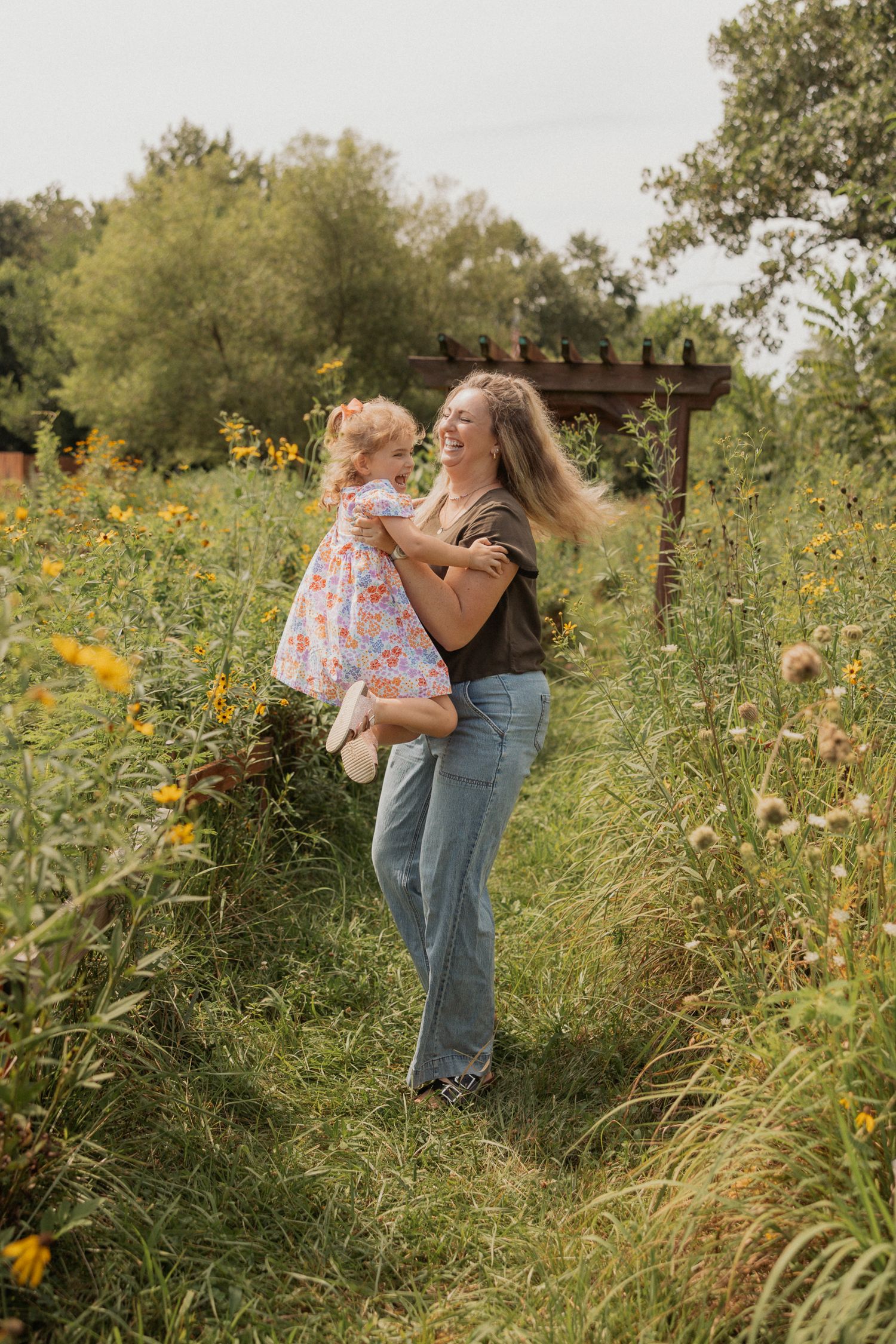 Sweet moments shared between two people in a field of wild sunflowers and tall grass.