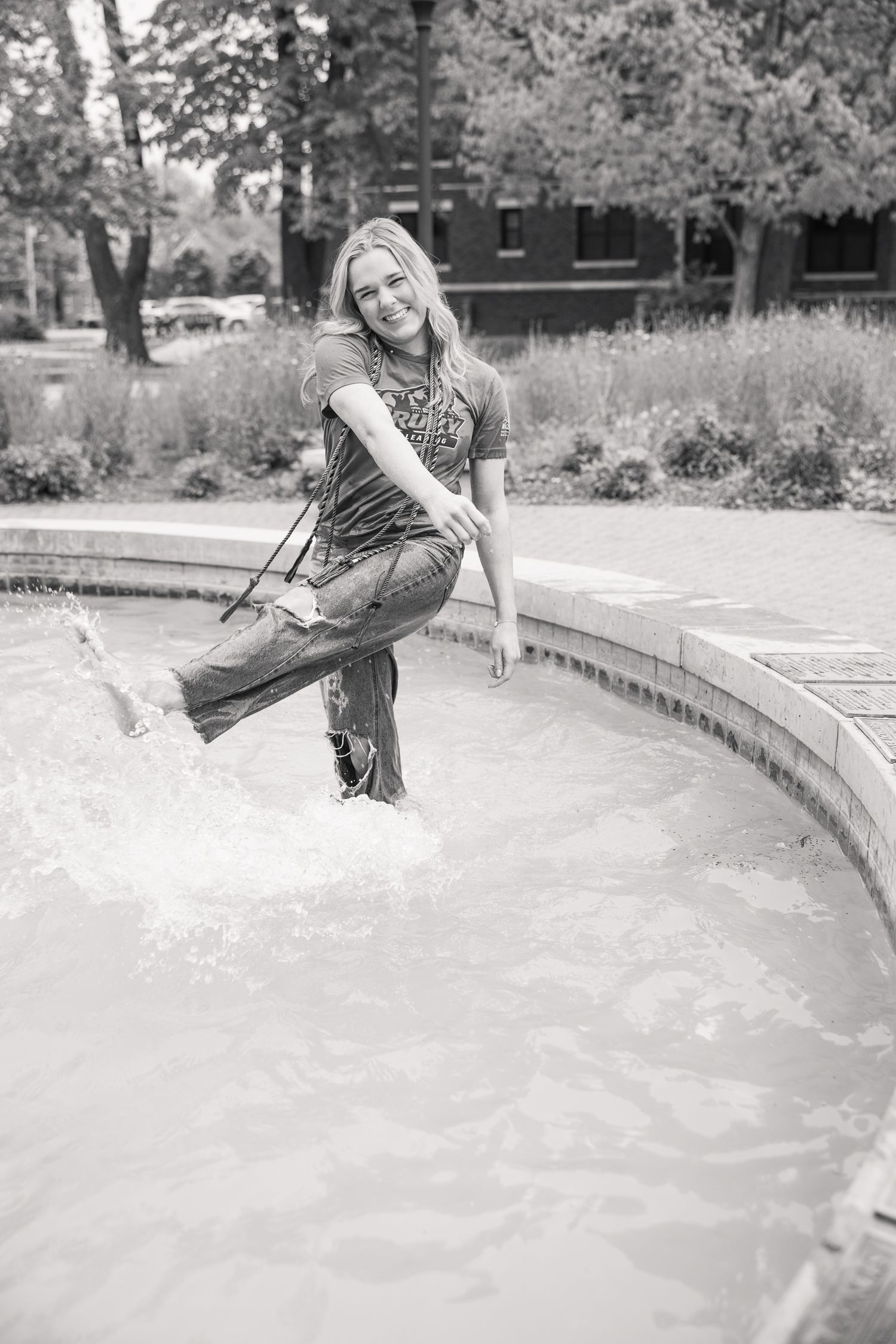 Person splashing and playing in outdoor fountain on warm day.