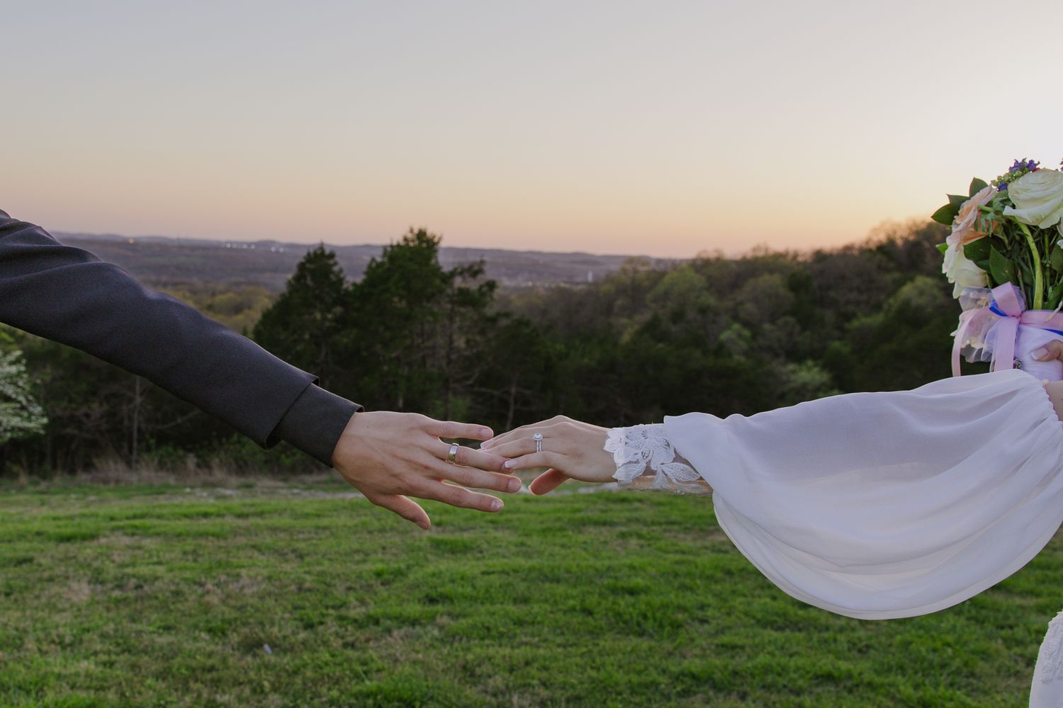 Scenic outdoor wedding photography with white fabric flowing in the breeze against a natural landscape.