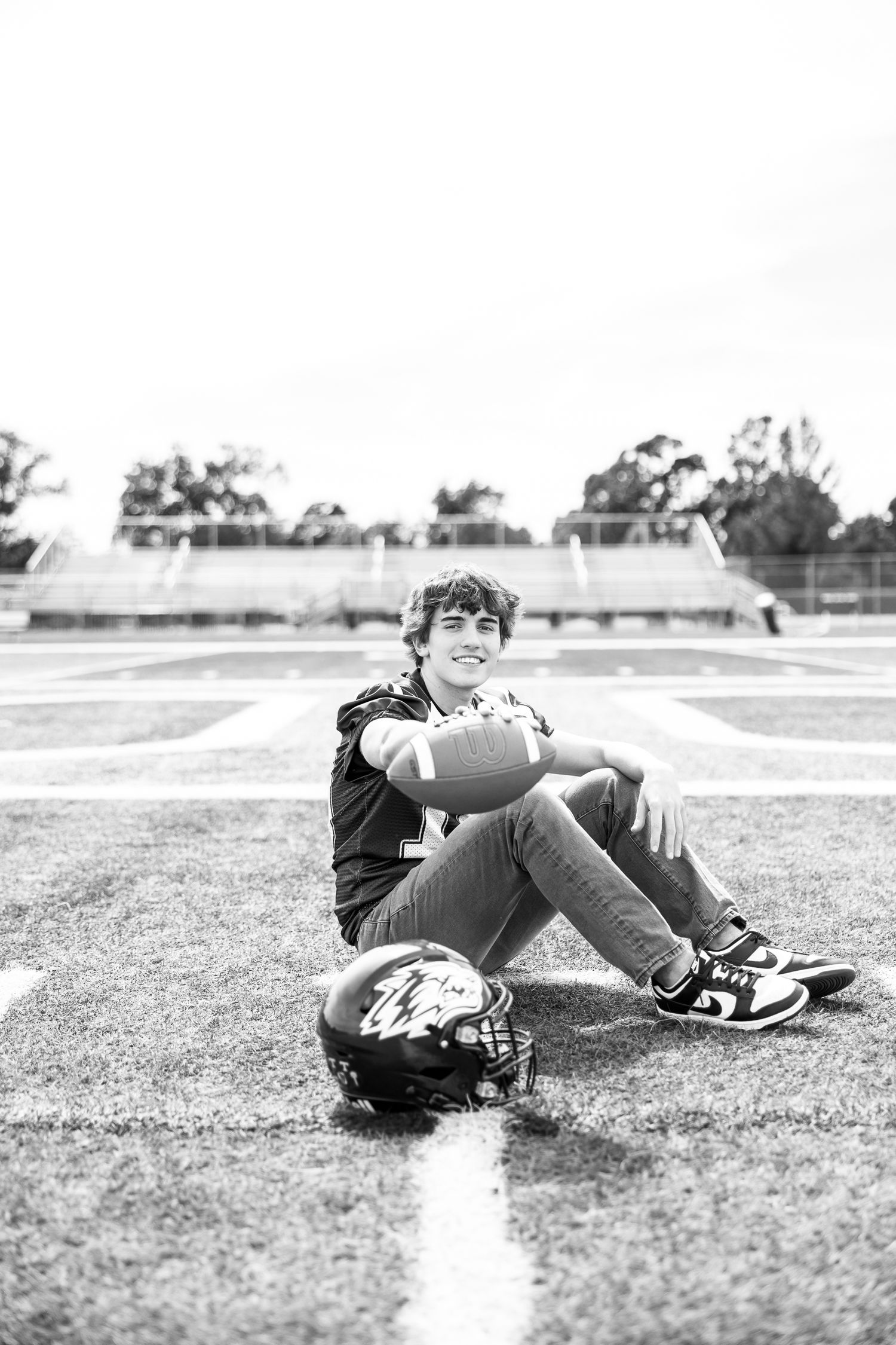 Black and white series of player reclining on football field grass.