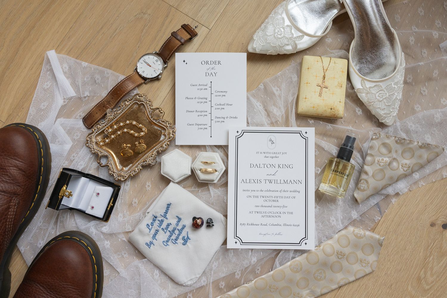 Wedding details including invitations, rings, and decorative elements arranged on a wooden surface.