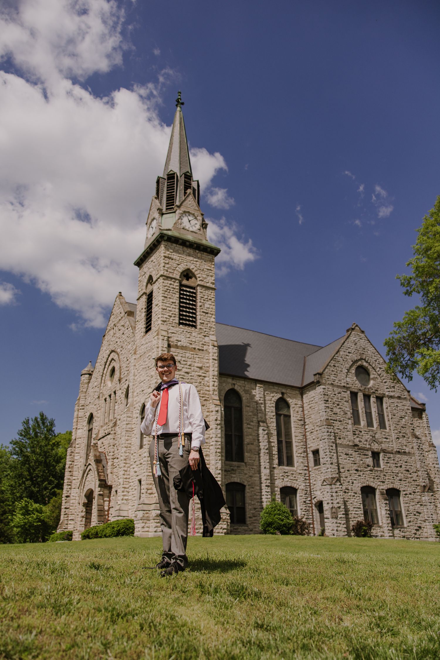 Historic stone church with gothic architecture photographed from hillside angle.