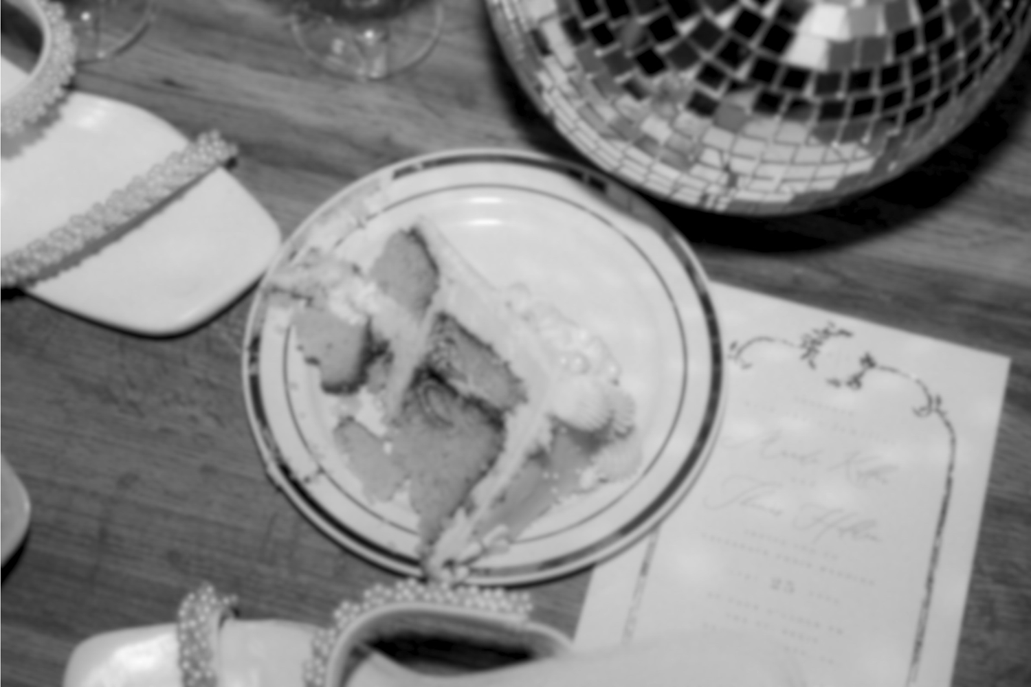Black and white overhead shot of a plate with food and table settings.
