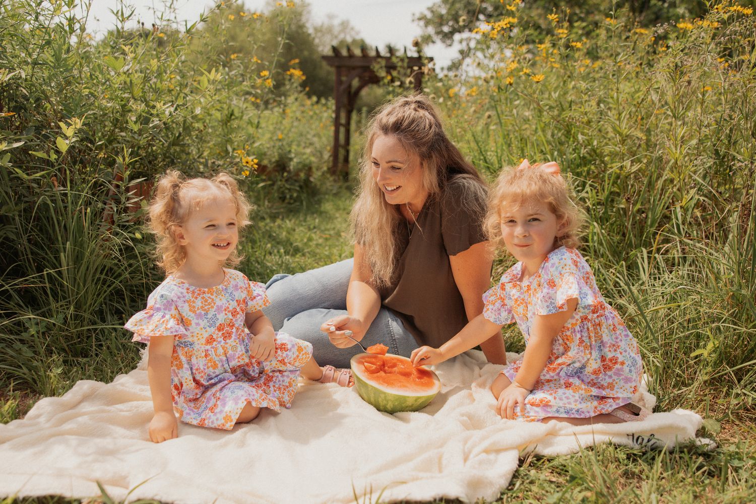 A relaxed summer picnic with watermelon in a garden setting with yellow flowers.