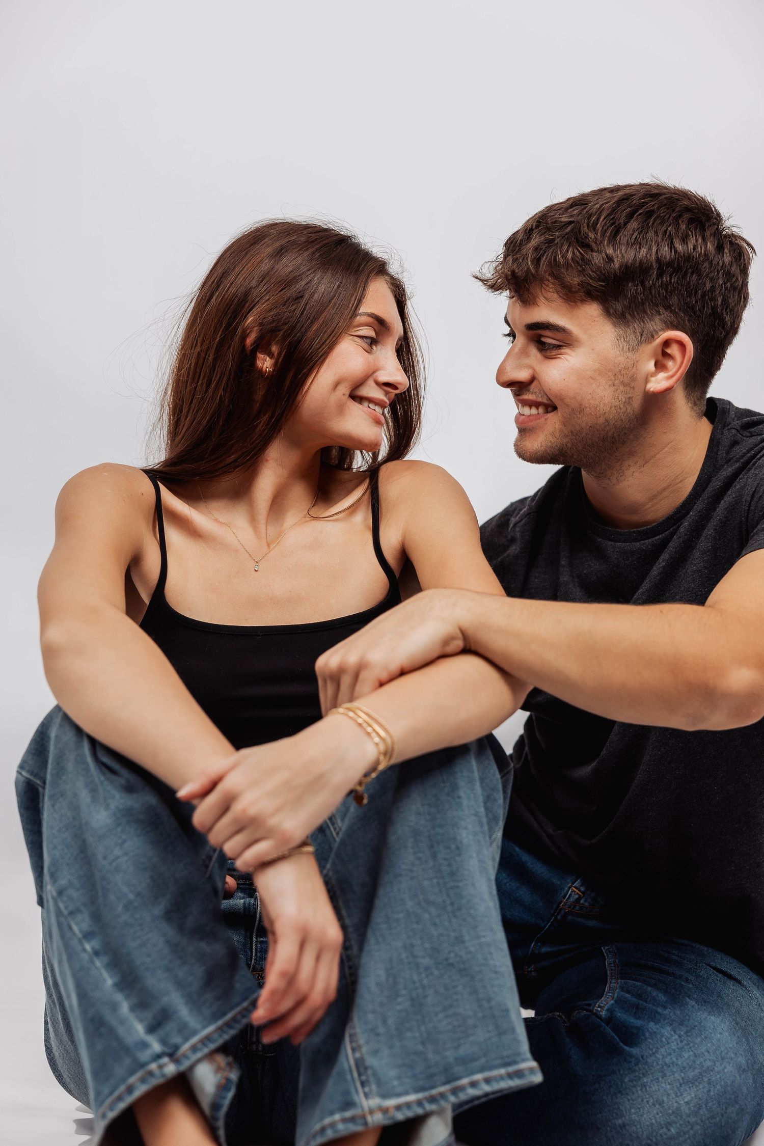Candid moments of couple embracing and laughing together in studio setting.