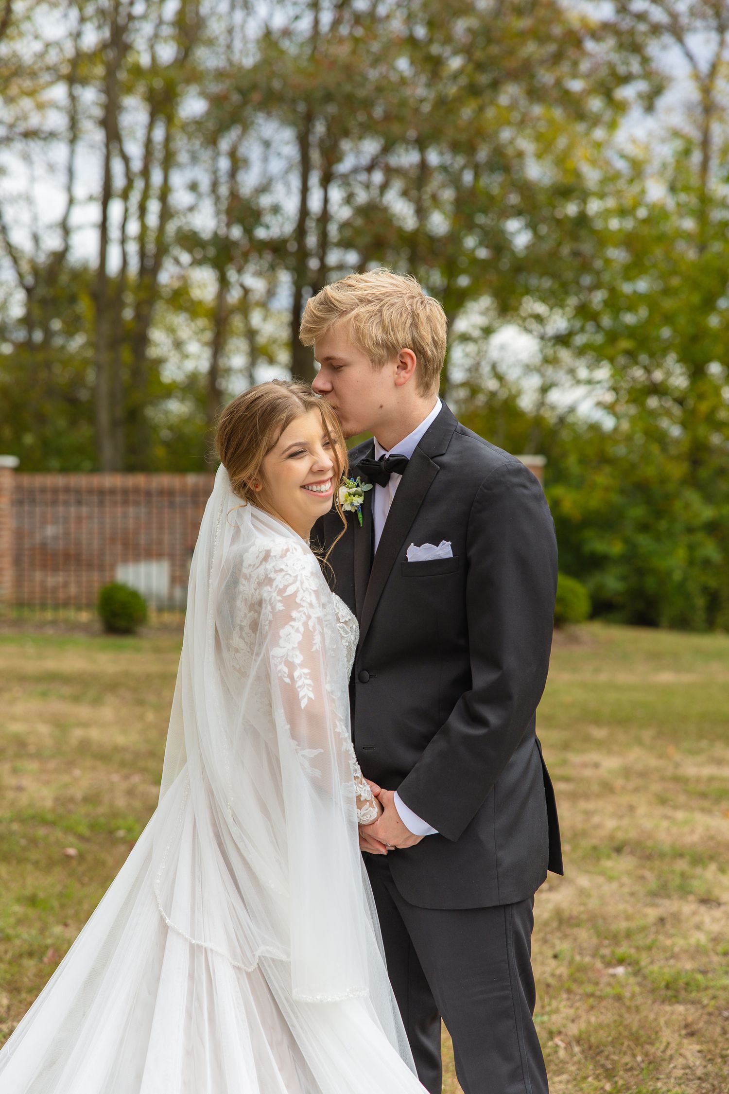 Romantic outdoor wedding photos showing flowing white dress against autumn trees.