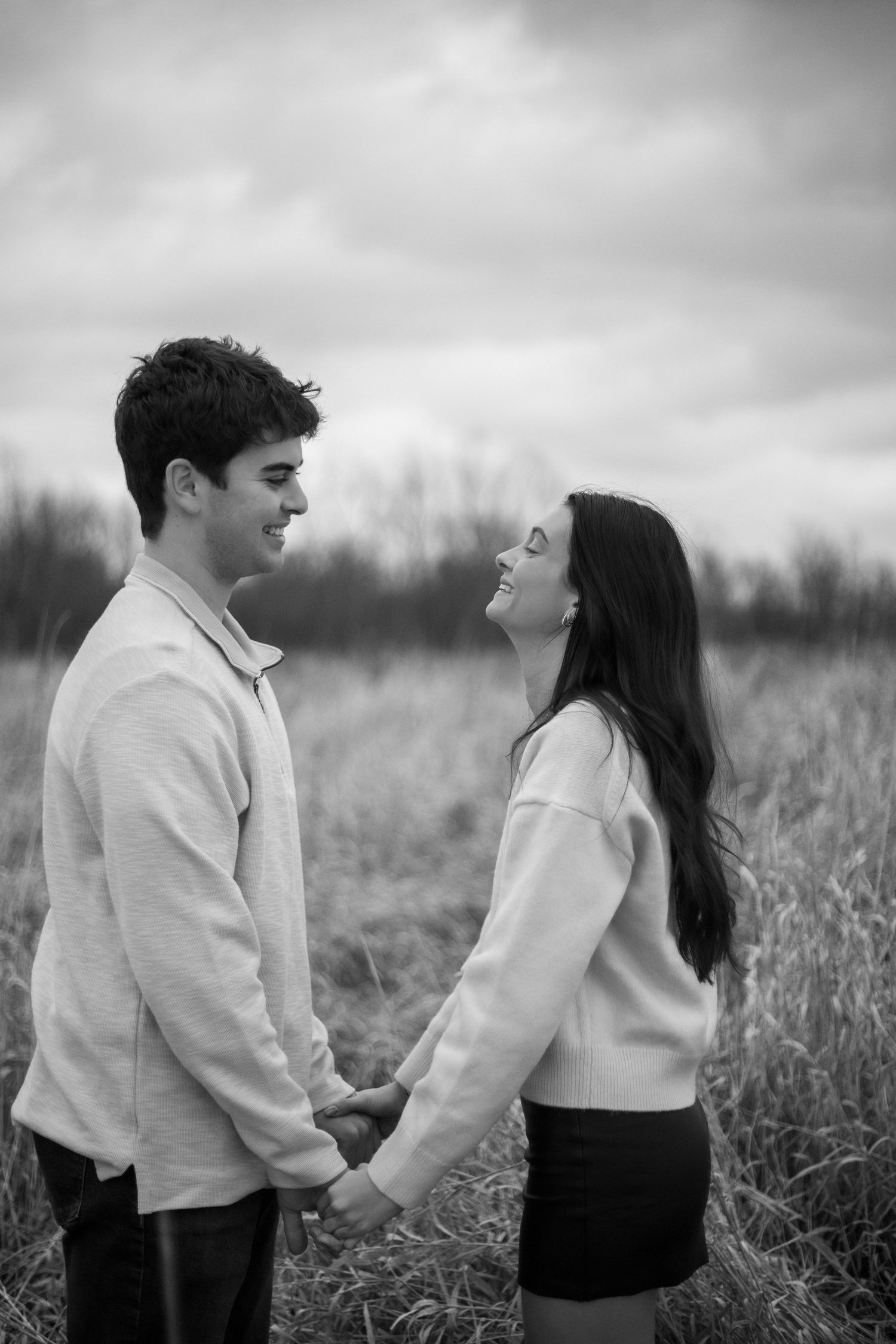 Romantic black and white photo series showing playful interactions in a natural field setting.