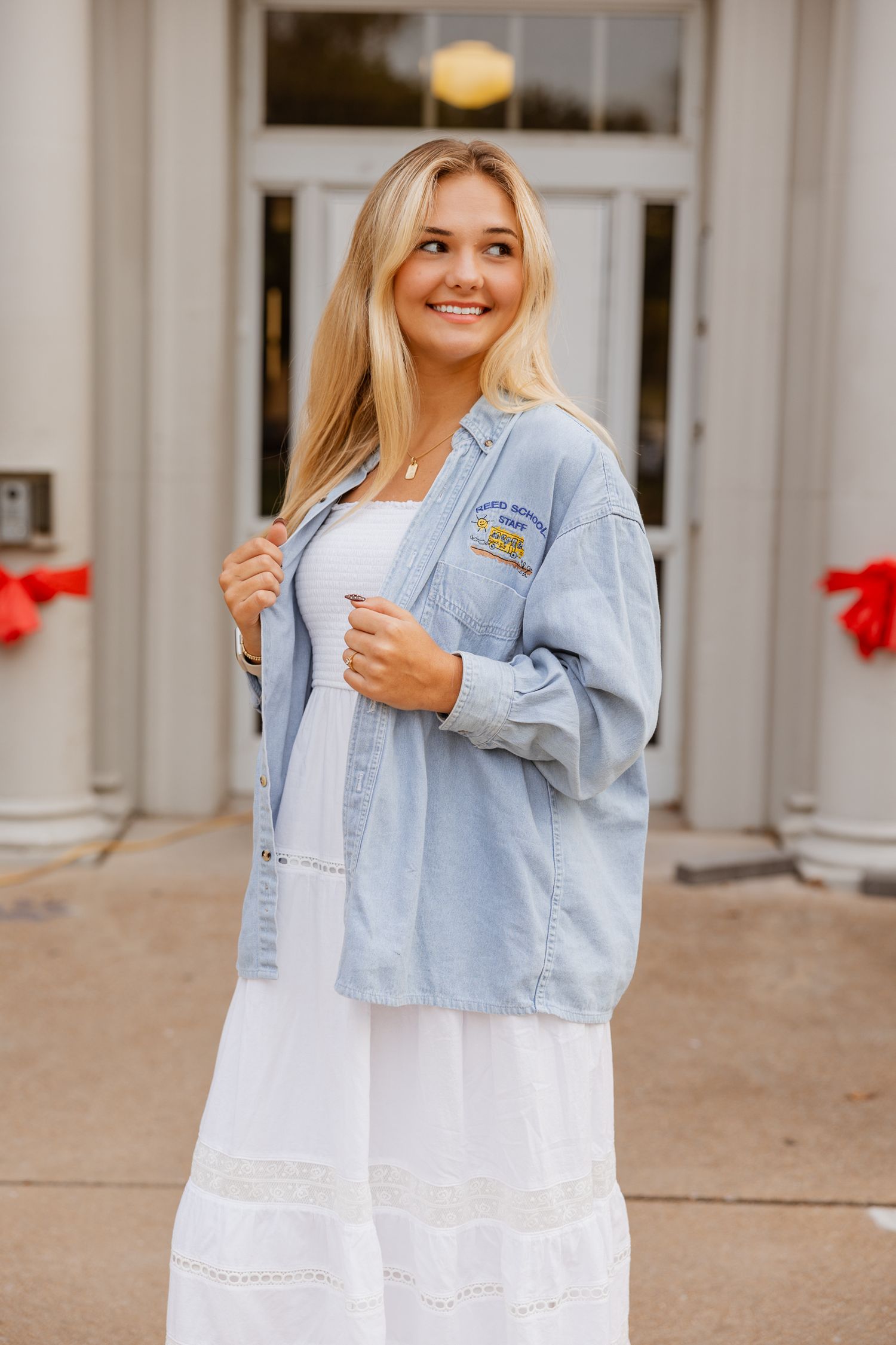 Light denim jacket paired with white dress photographed at school building entrance.
