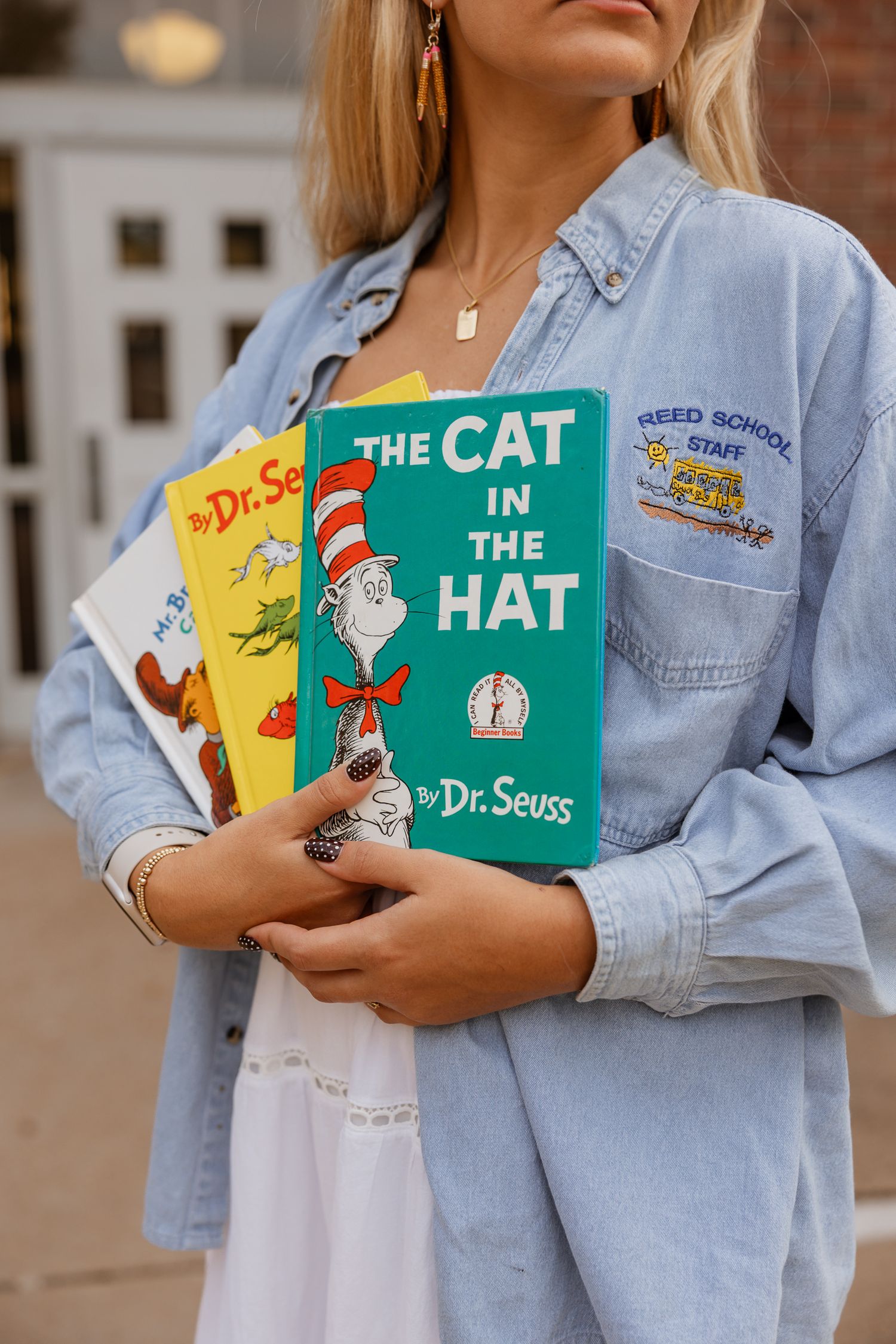 Classic Dr. Seuss books are displayed against a light denim jacket and white dress outfit.