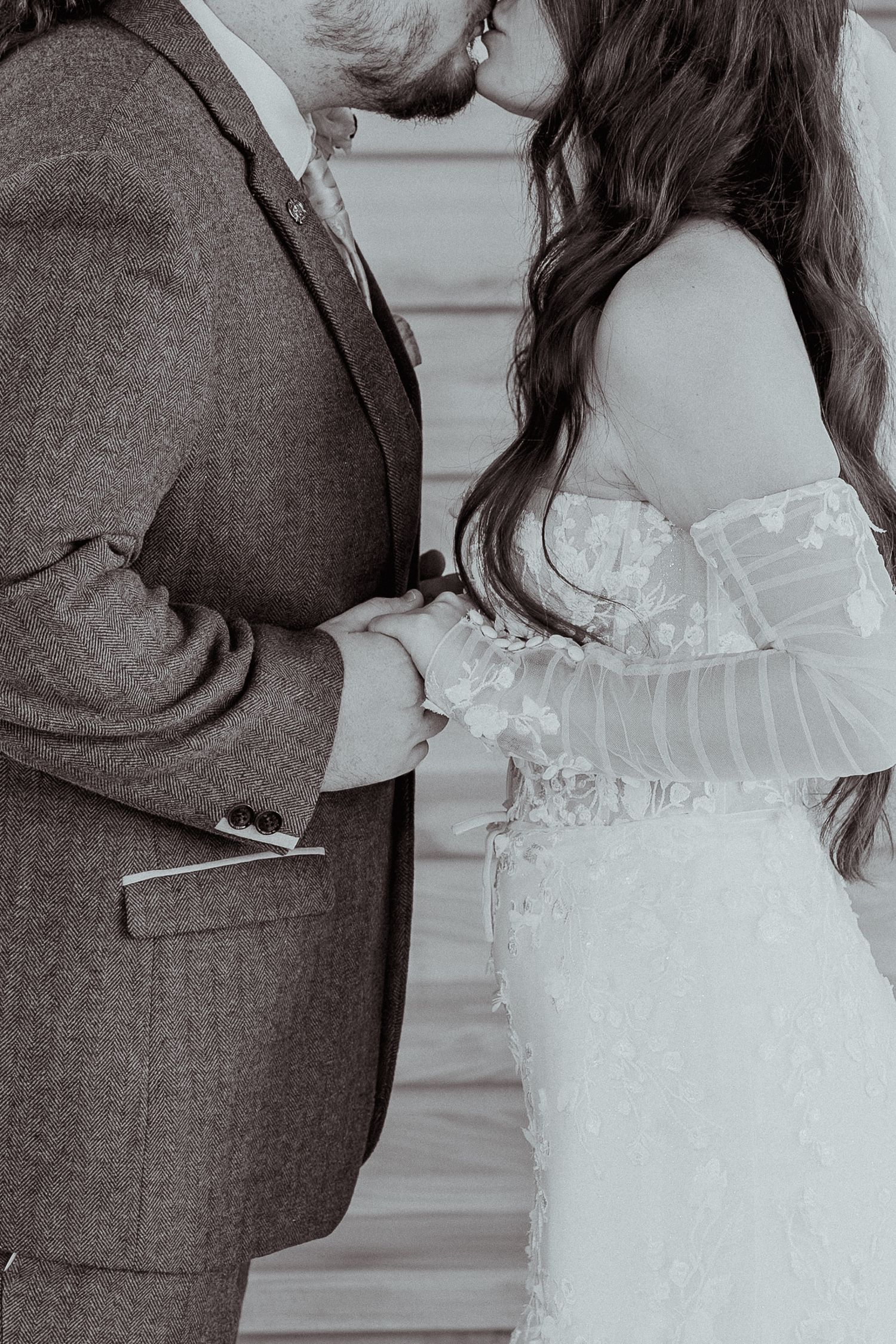 Black and white close-up of a couple in wedding attire sharing an intimate moment.